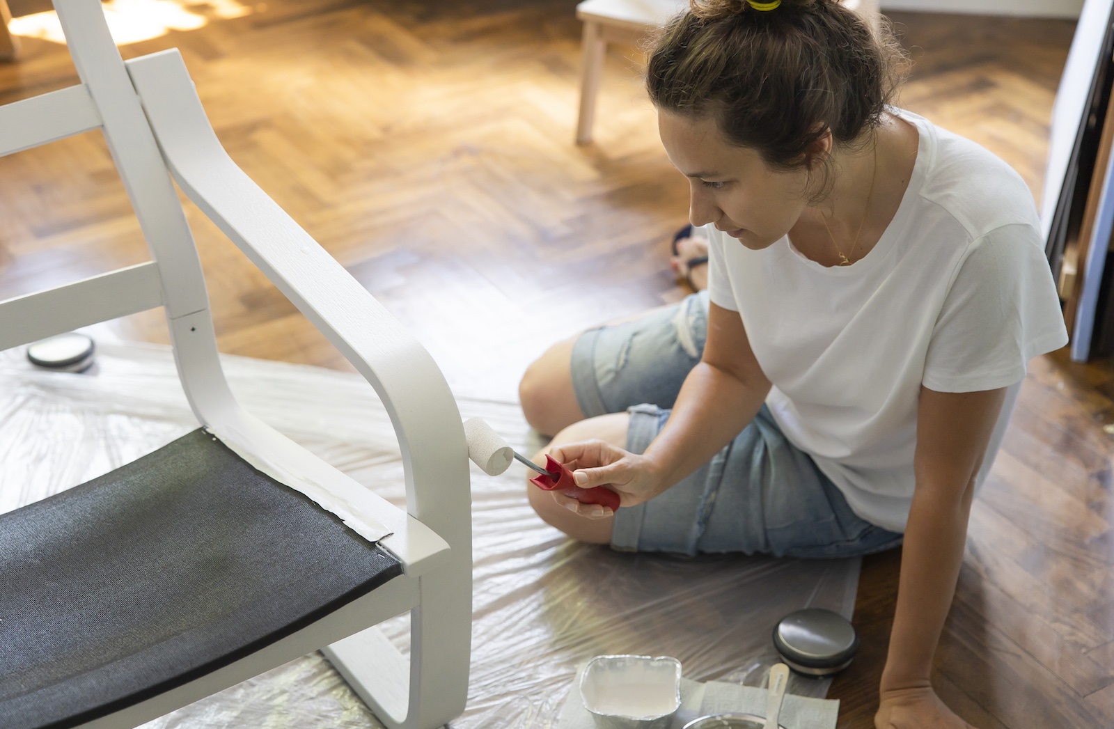 junge Frau streicht Sessel im Sitzen