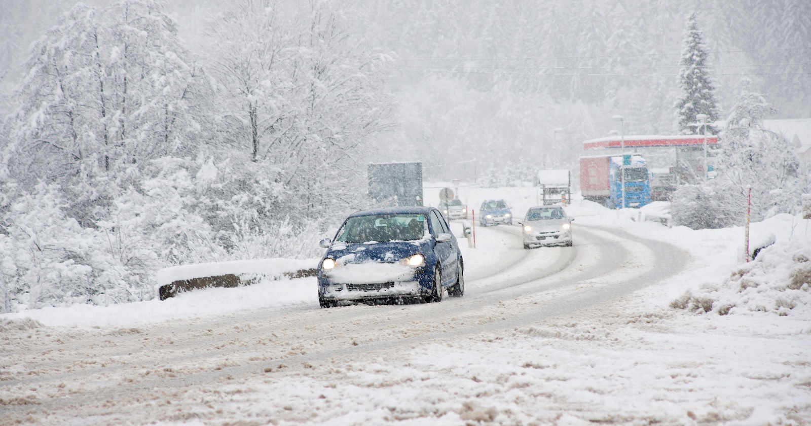 Autos auf einer schneebedeckten Fahrbahn.