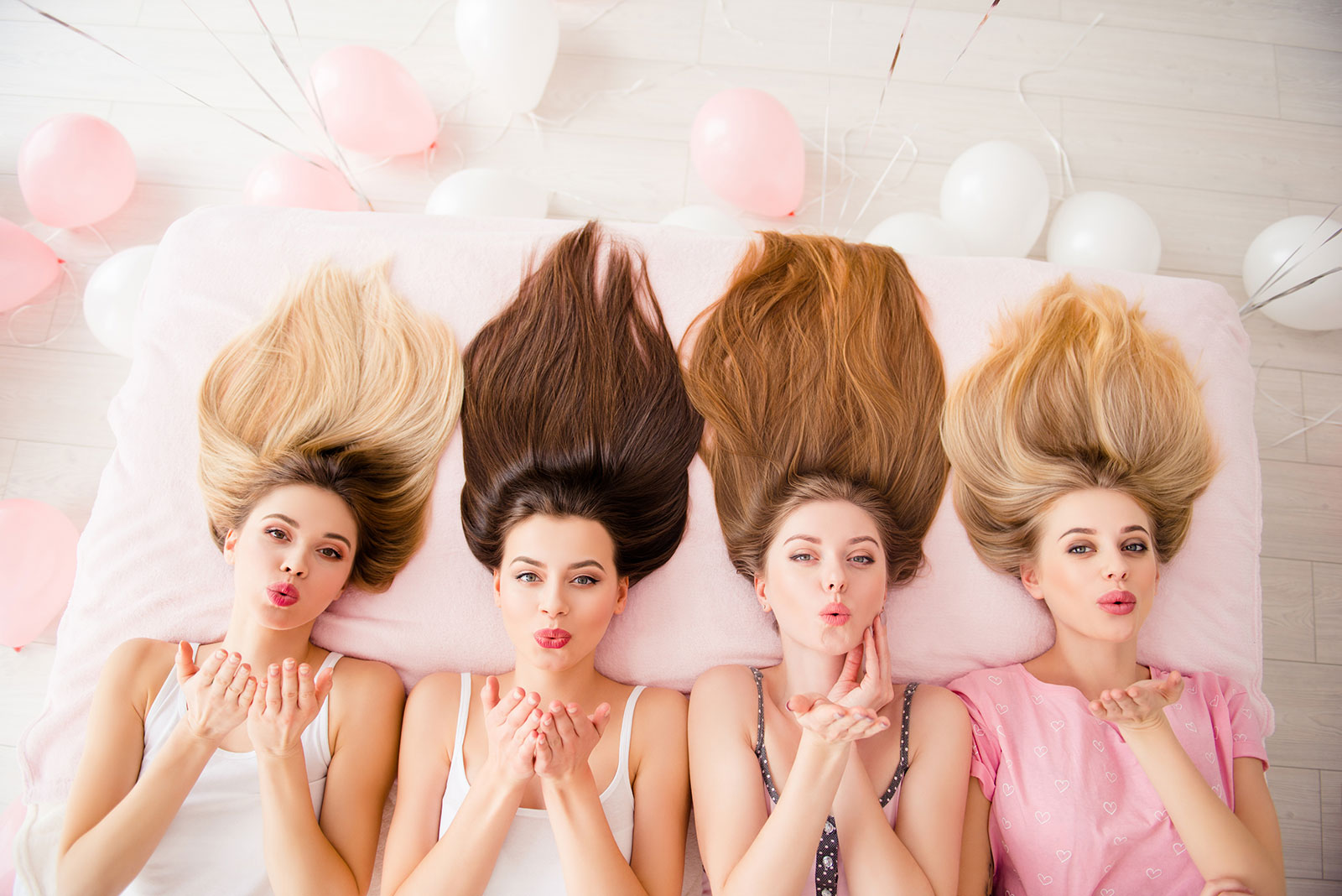 Vier nebeneinander liegende Frauen mit langen Haaren in unterschiedlichen Farben | Credit: iStock.com/Deagreez