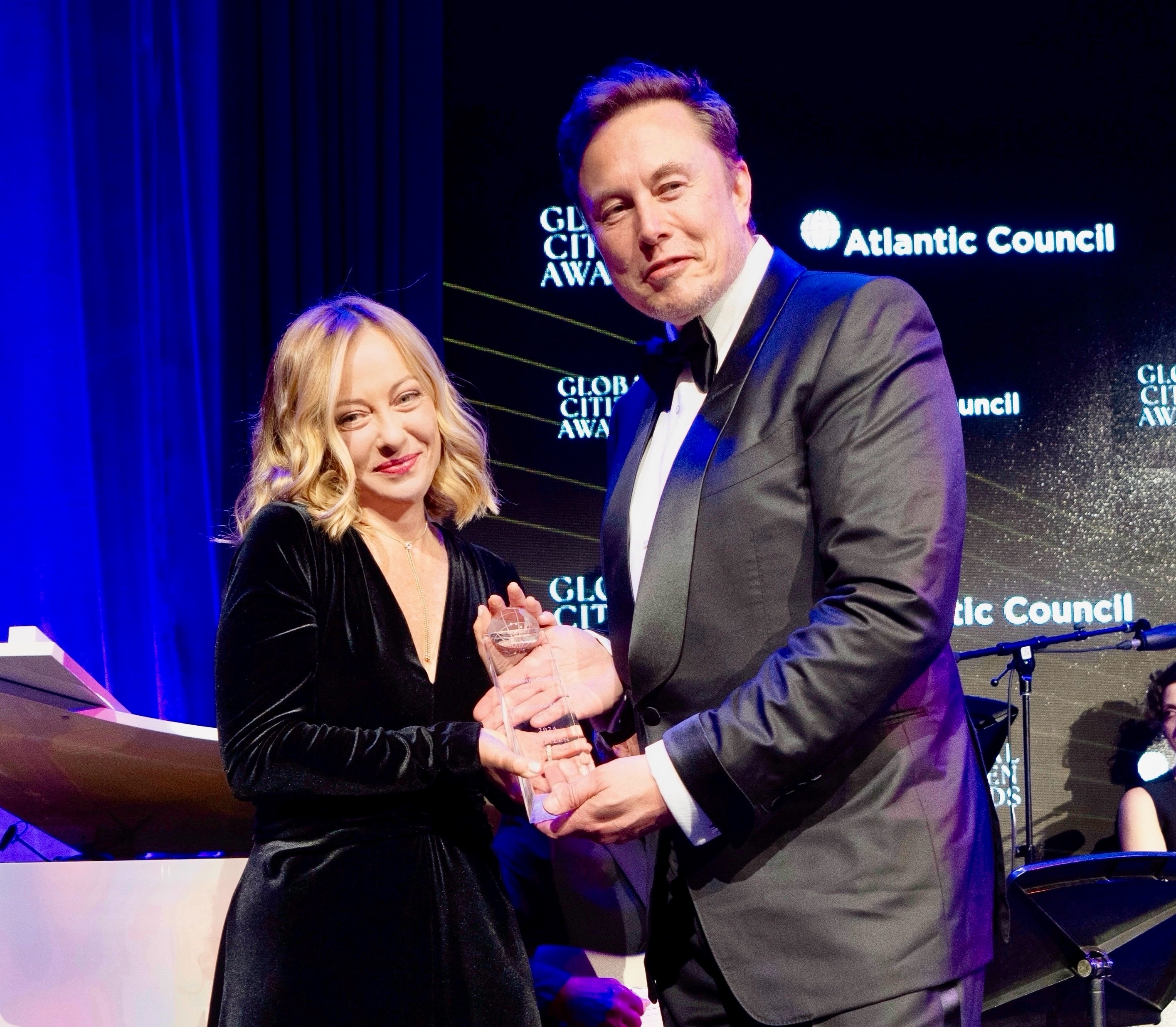 Giorgia Meloni, die auf einer Gala eine Auszeichnung aus den Händen Elon Musks erhält