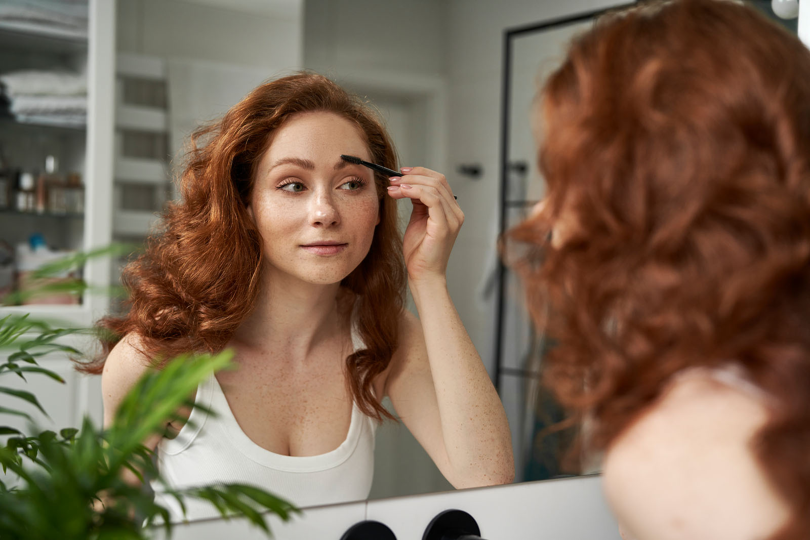 Frau bürstet ihre Augenbrauen | Credit: iStock.com/gpointstudio