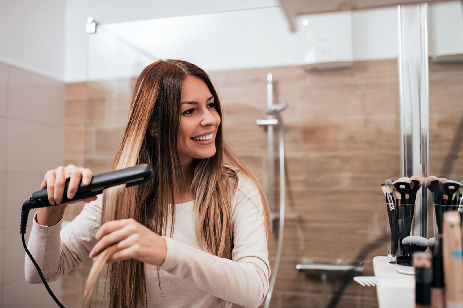 Frau glättet ihre Haare | Credit: iStock.com/nortonrsx