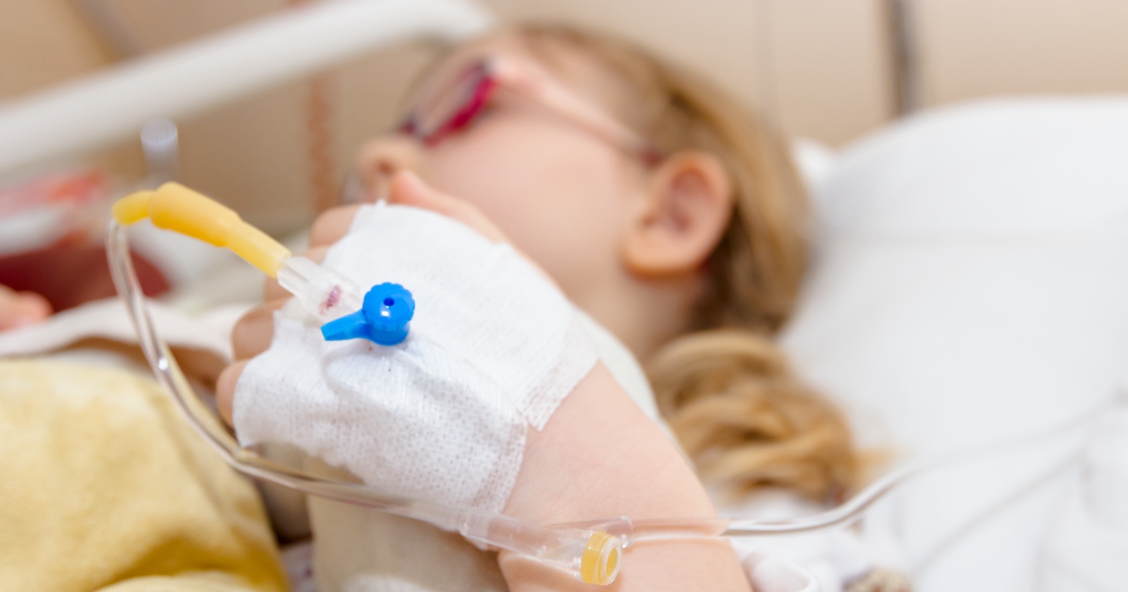 Ein kleines Mädchen liegt in einem Krankenhausbett.