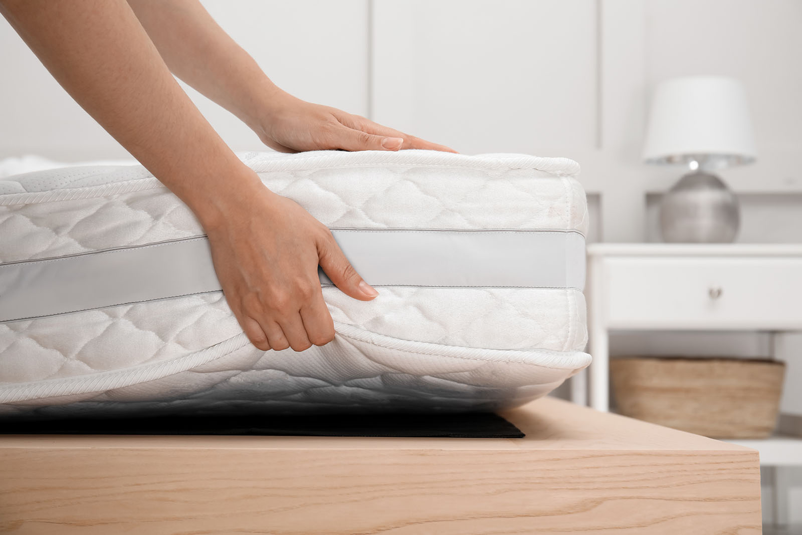 Frau legt Matratze auf Lattenrost | Credit: iStock.com/Liudmila Chernetska