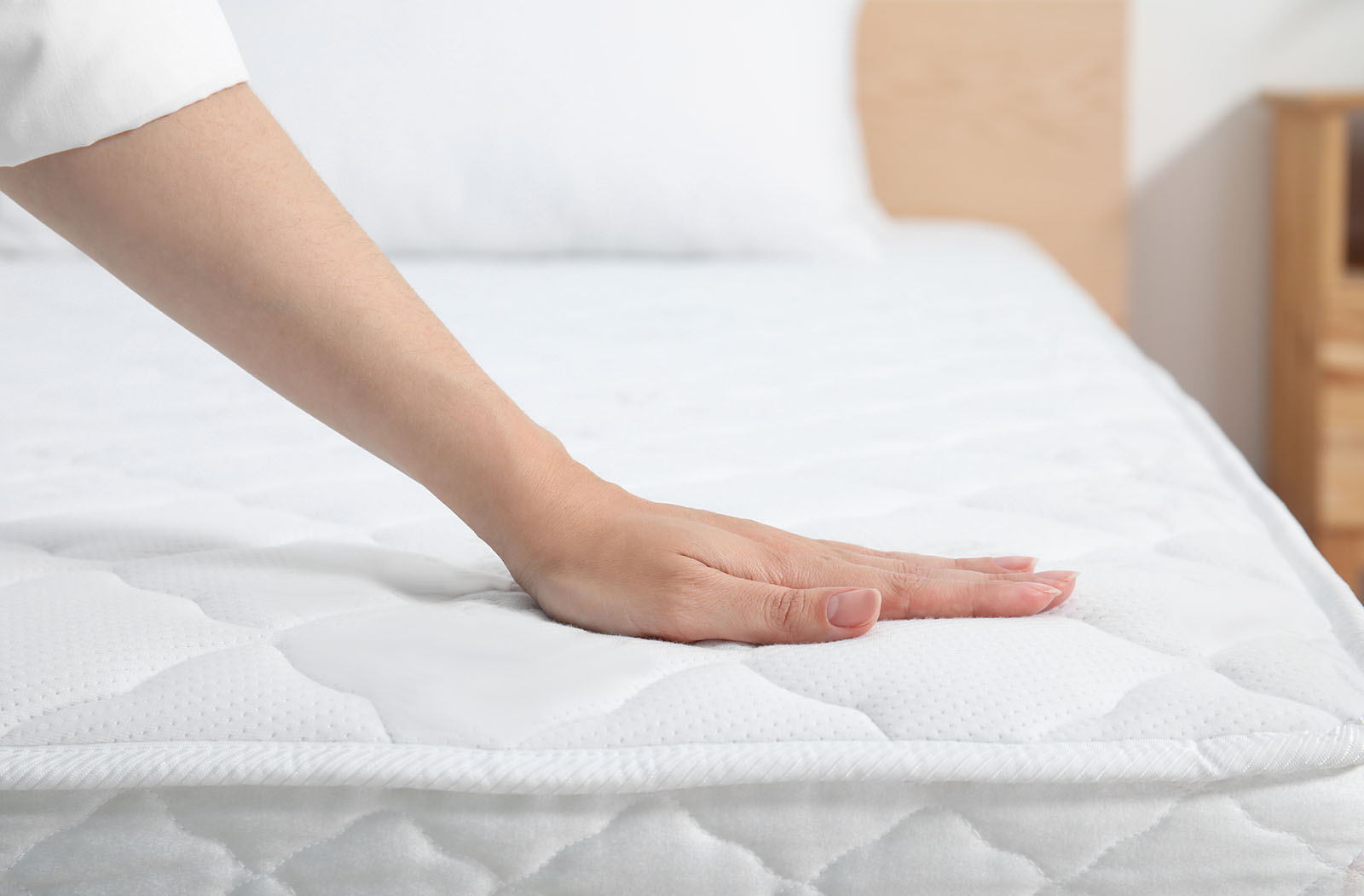 Frau streicht über die gereinigte Matratze | Credit: iStock.com/Liudmila Chernetska