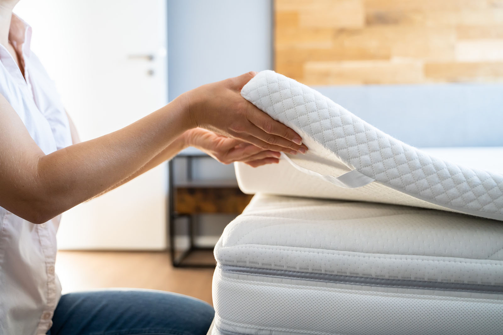 Frau legt Topper auf Matratze | Credit: iStock.com/AndreyPopov