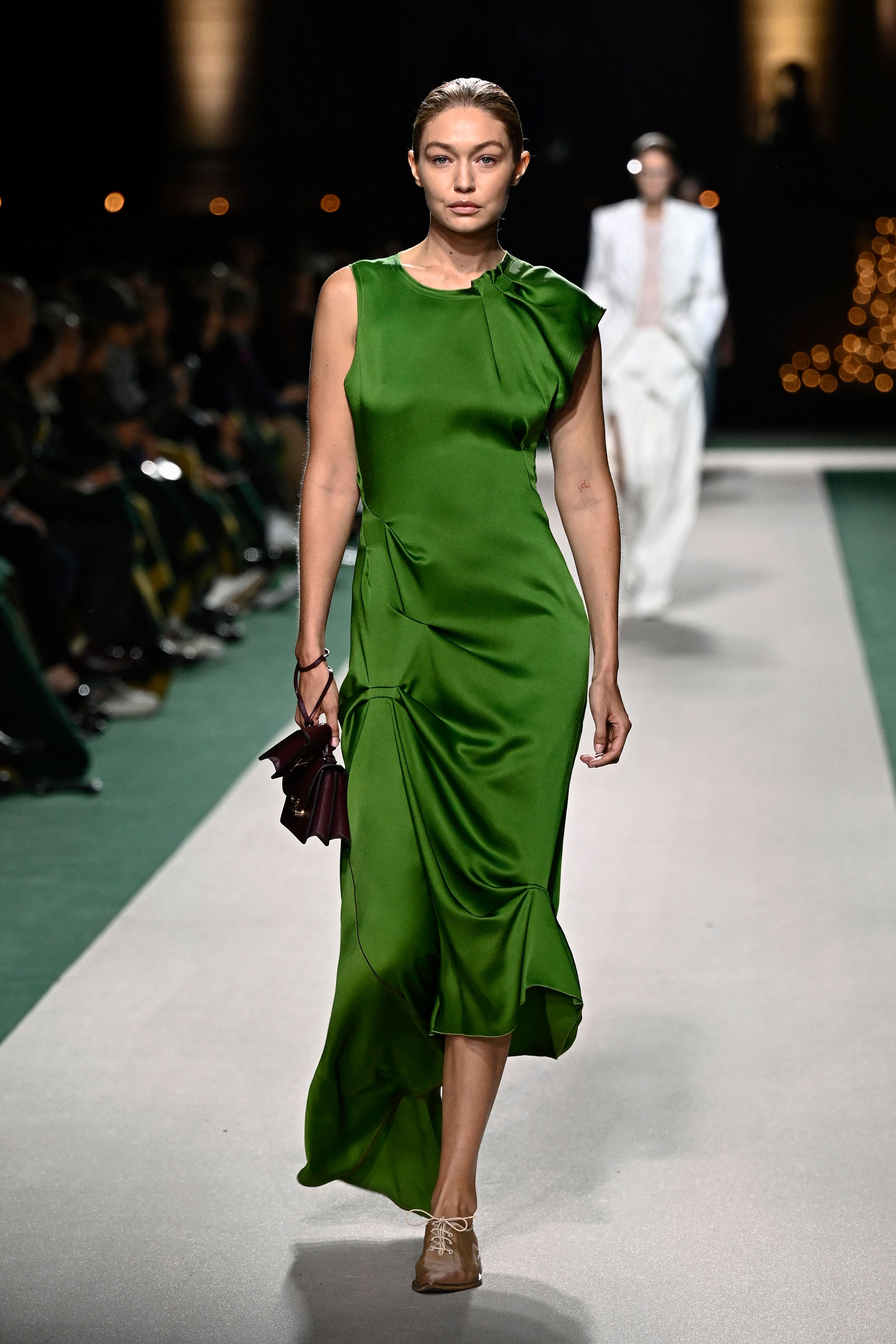 Model in einem grünen Kleid am Laufsteg