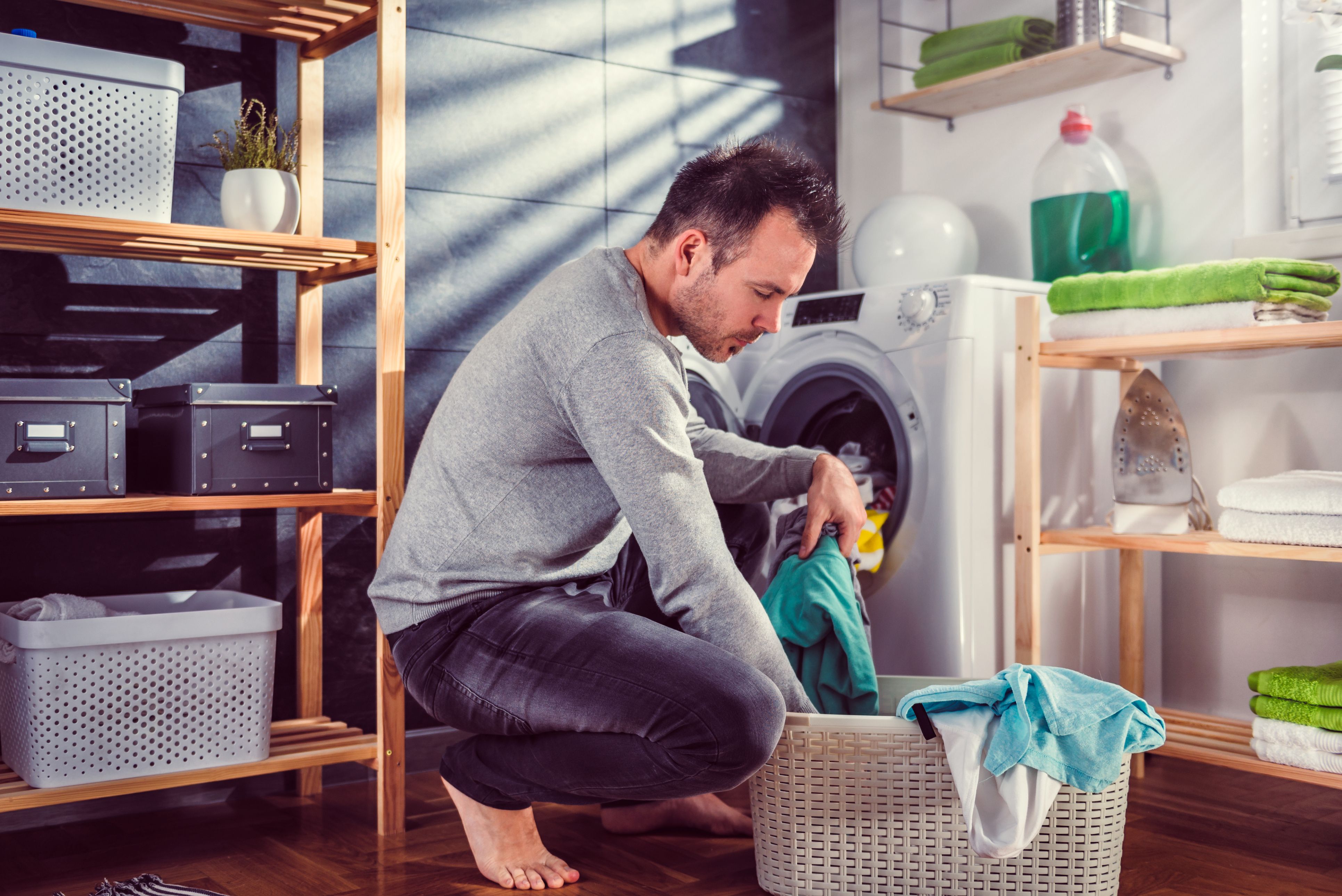 Mann füllt Waschmaschine | Credit: iStock.com/Kerkez