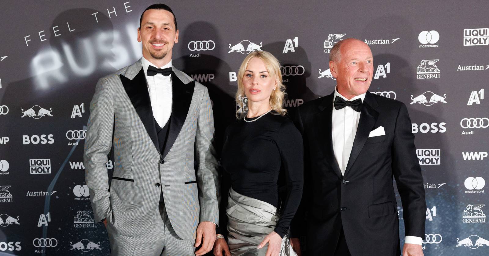 Zlatan Ibrahimovic mit Partnerin Helena Segel und Veranstalter Harti Weirather in eleganter Abendgarderobe vor der Sponsoren-Wand des roten Teppichs der Veranstaltung "KitzRaceParty 2025 - Red Carpet"