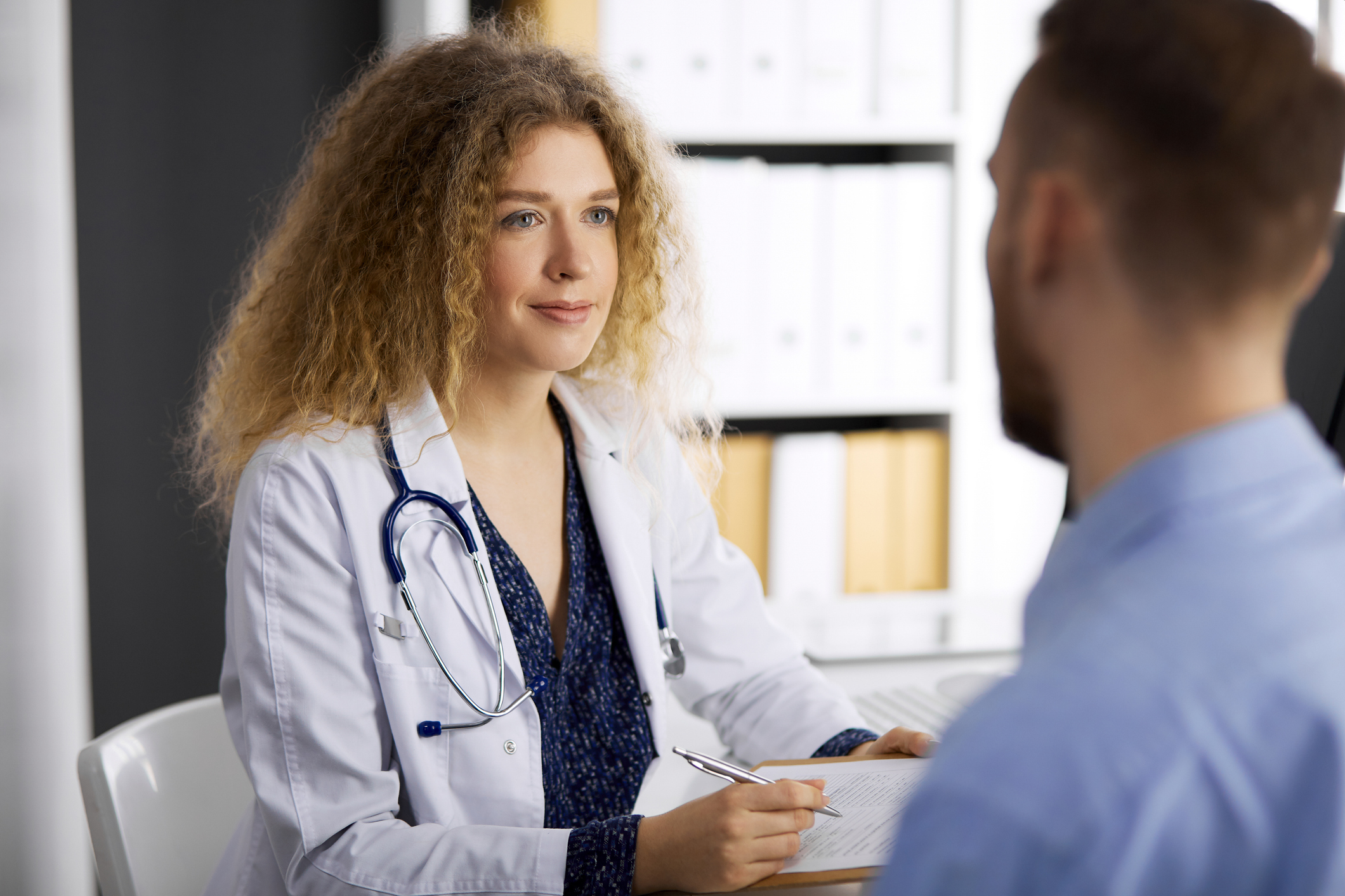 Eine Ärztin spricht mit einem Patienten