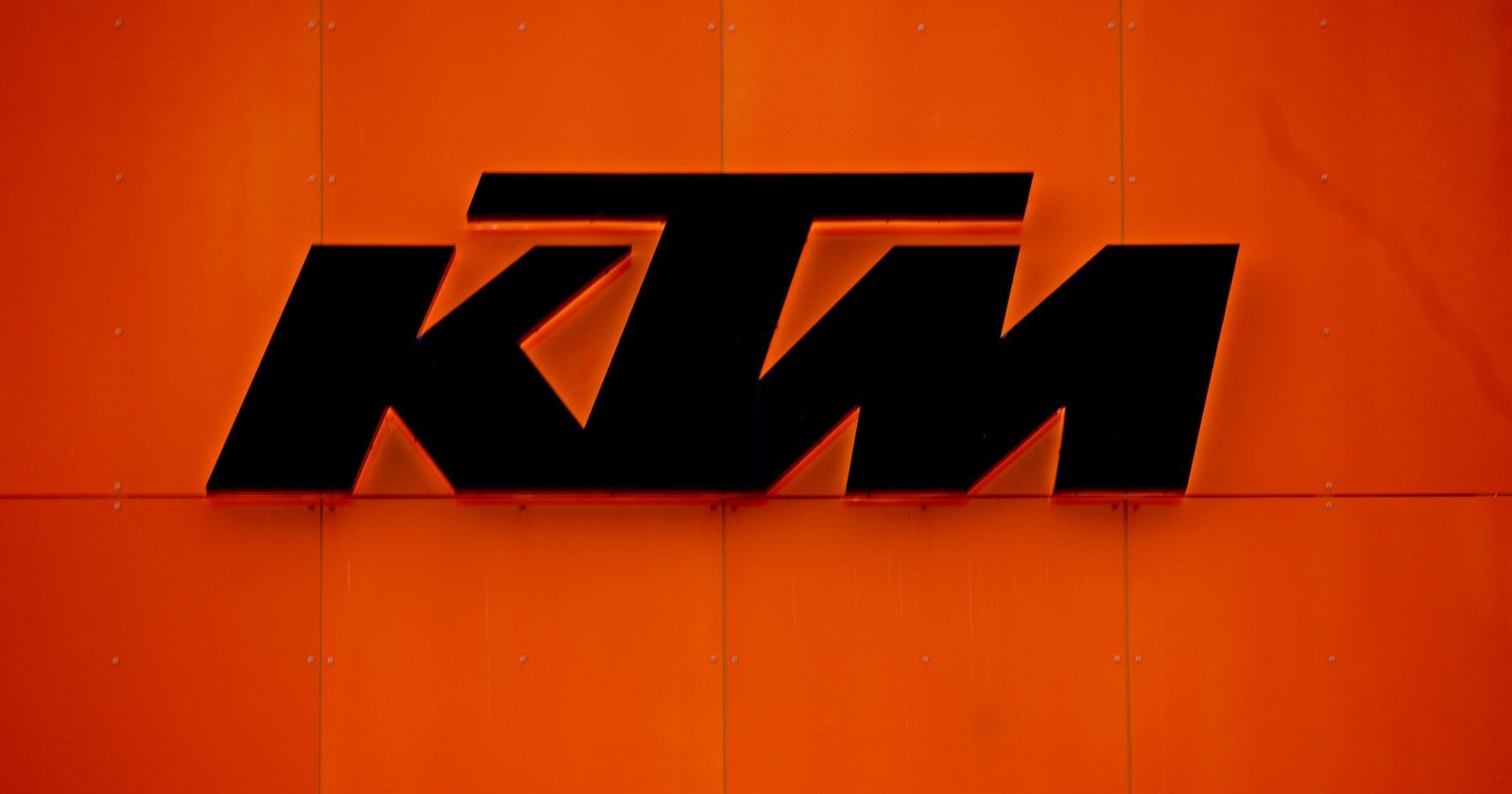 KTM-Logo auf orangefarbener Wand – Symbolbild zur erneuten Produktionspause beim Motorradhersteller KTM im April 2025.