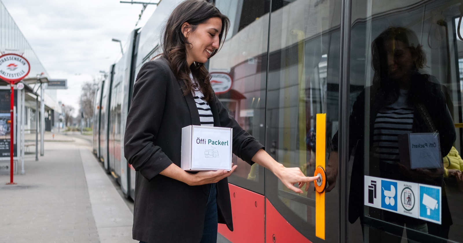 Frau steigt mit Paket in eine Wiener Straßenbahn ein