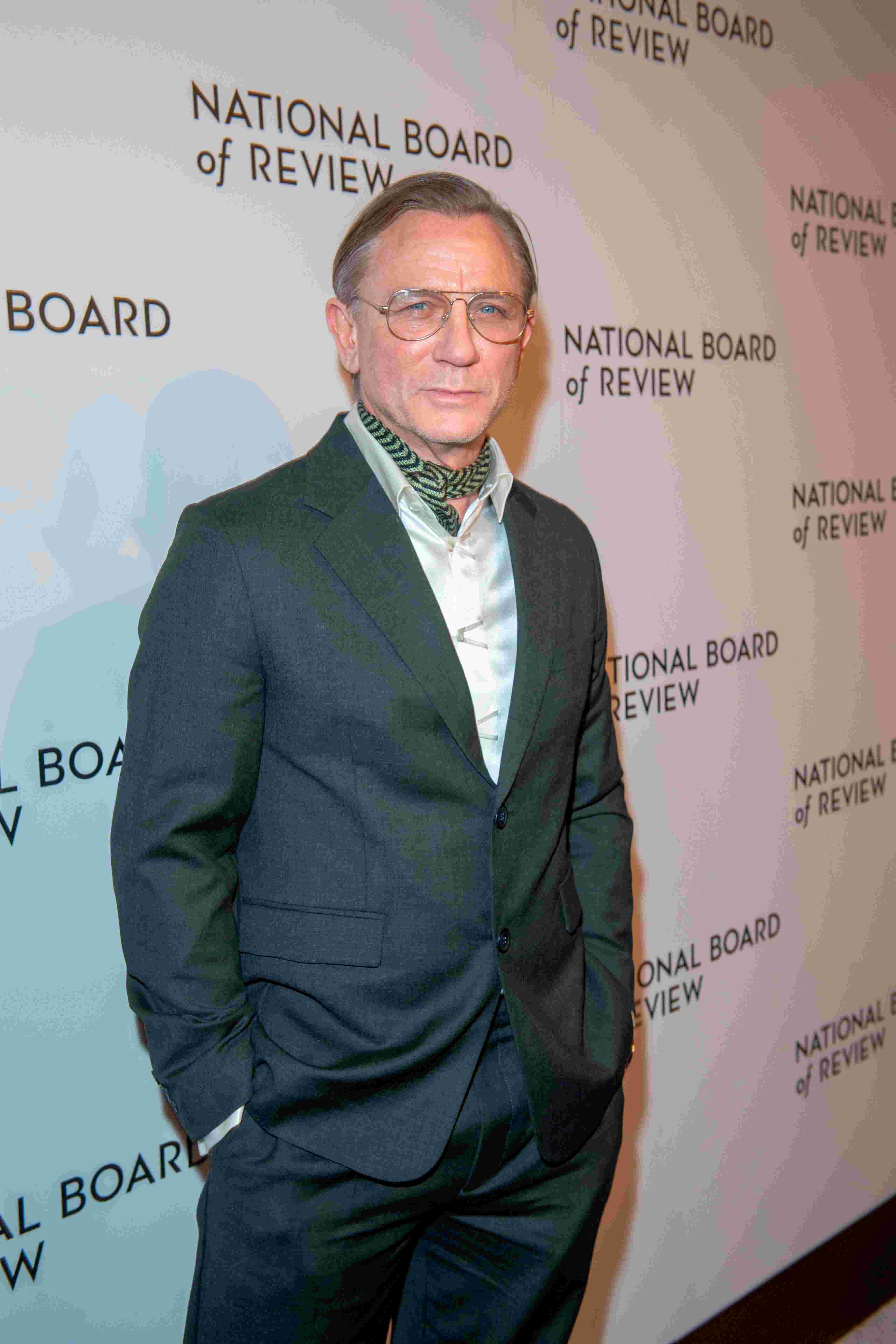 Daniel Craig trägt einen dunkelgrauen Anzug mit glänzendem Hemd und Halstuch auf dem roten Teppich bei der National Board of Review Gala