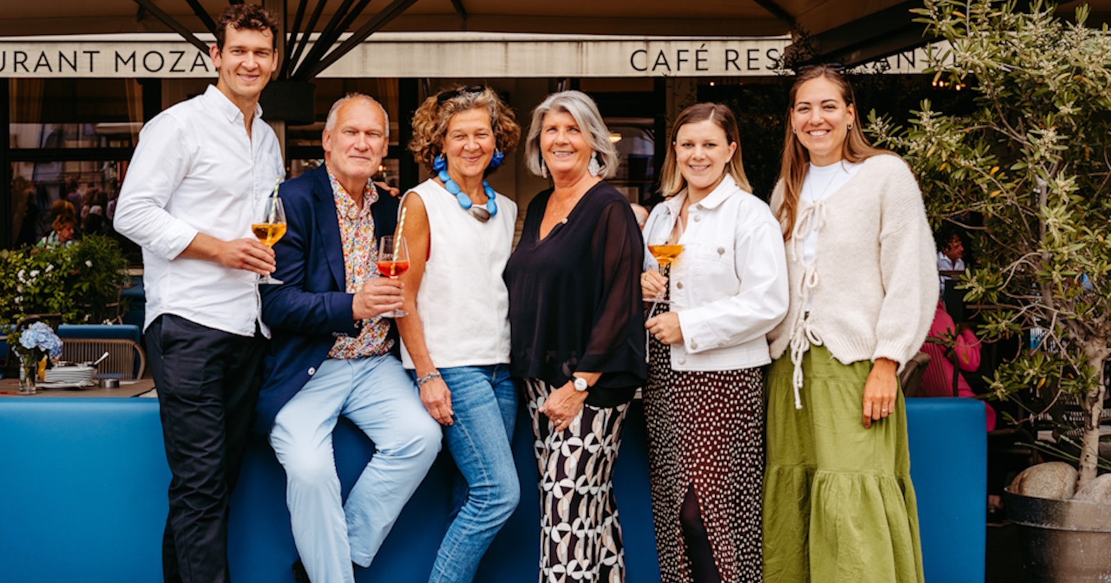 Familie Querfeld vor den neuen, blauen Sitzmöbeln im Schanigarten des Café Mozart