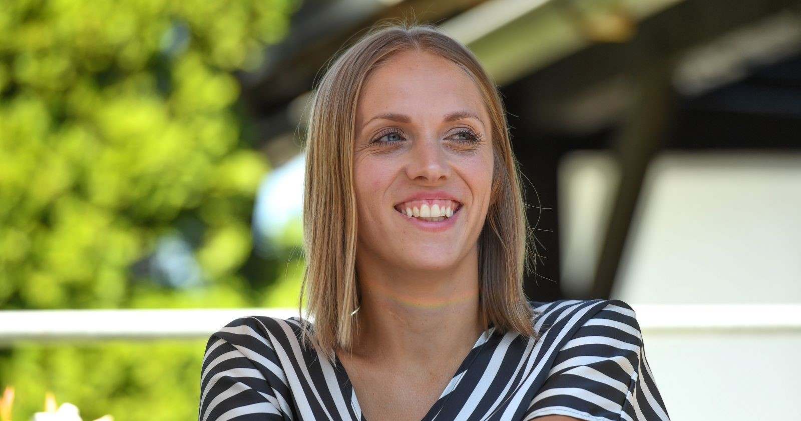 Porträt von Kira Grünberg, lächelnd im gestreiften Oberteil, aufgenommen im Freien. Zehn Jahre nach ihrem Unfall feiert sie den 30. Juli als „Life Day“.