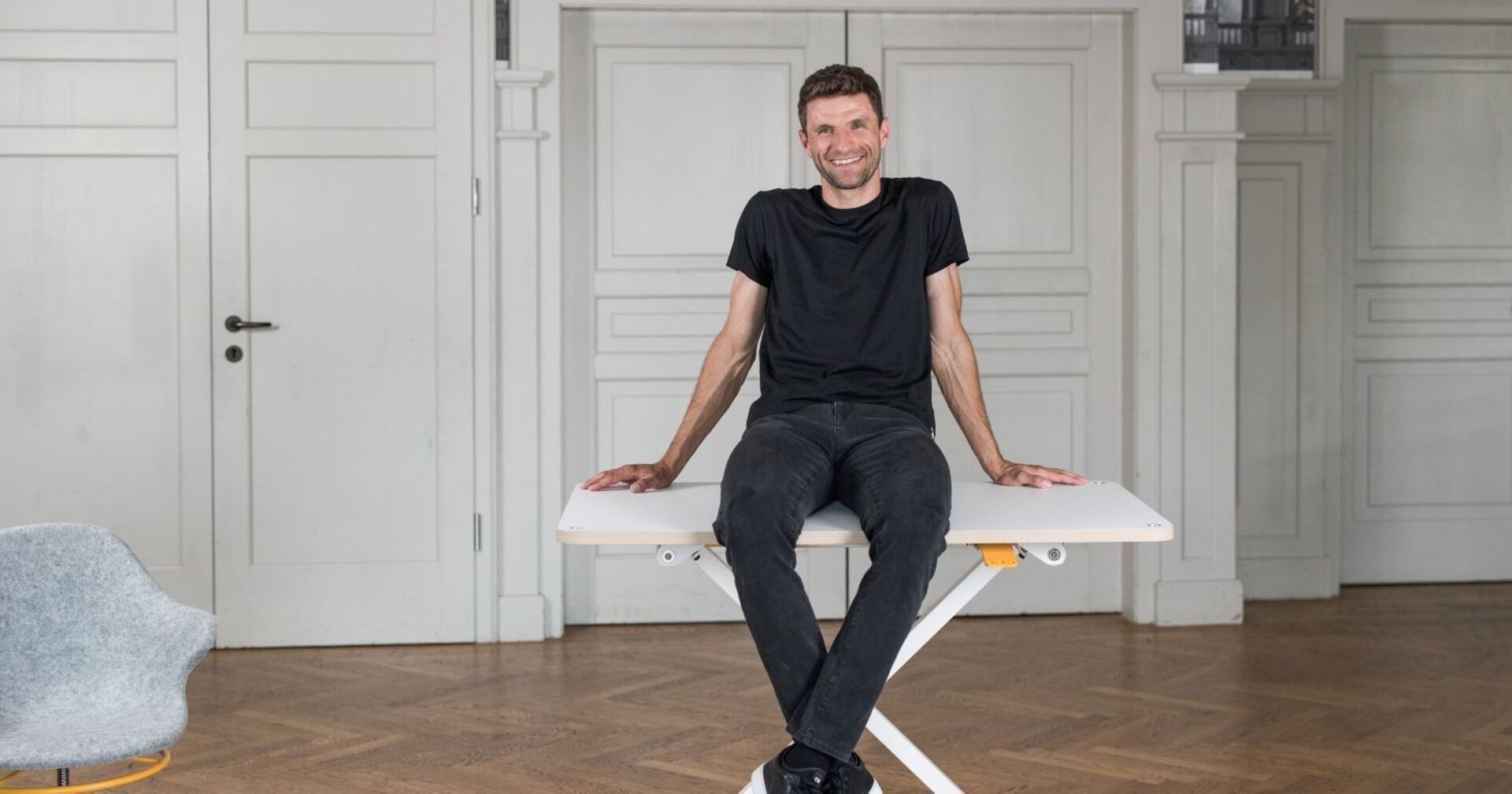 Thomas Müller sitzt auf einem Tisch der Firma poptop