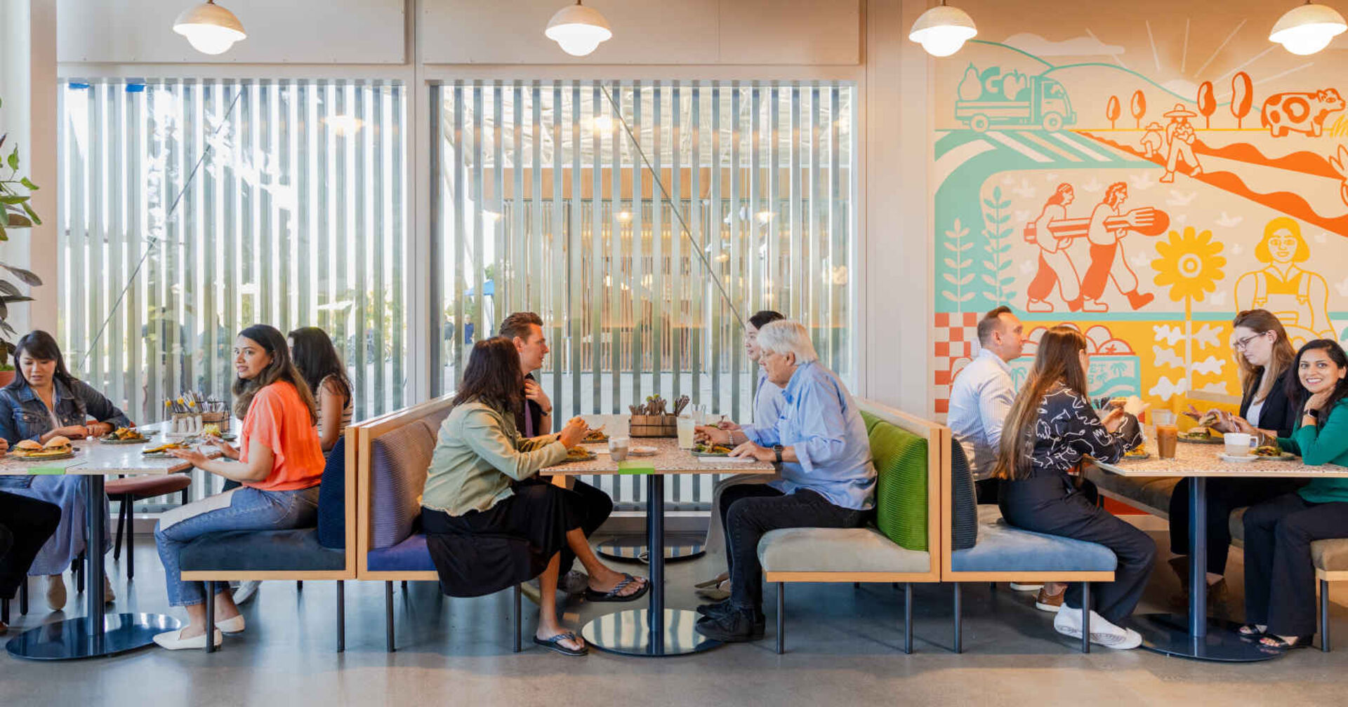 Mehrere Menschen sitzen in einer Kantine