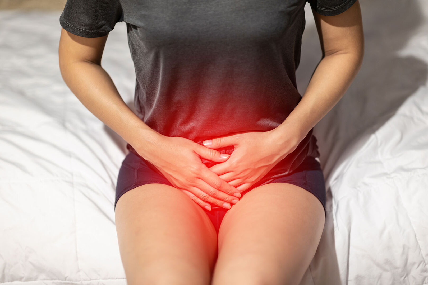 Frau hält Hände über ihren Unterbauch | Credit: iStock.com/Jomkwan