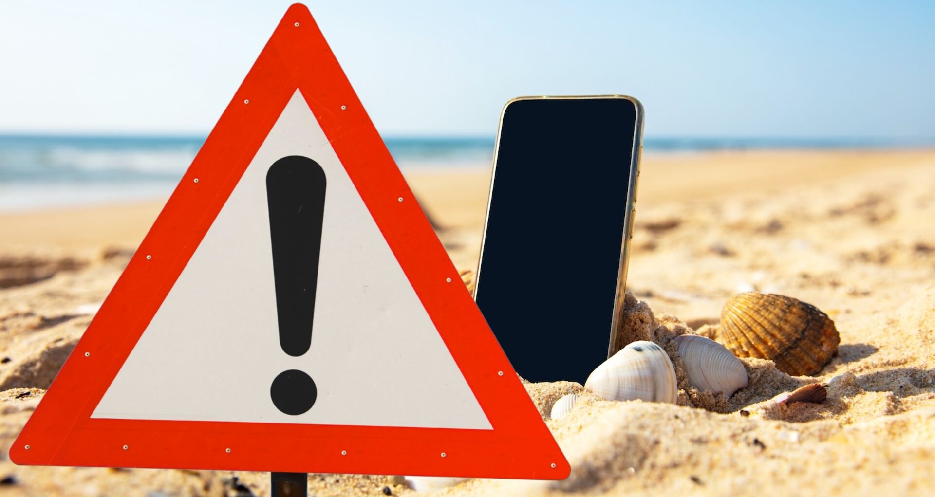 Warnschild und Handy im Sand am Strand: Symbolbild für Kostenfallen durch Handy-Nutzung im Urlaub.