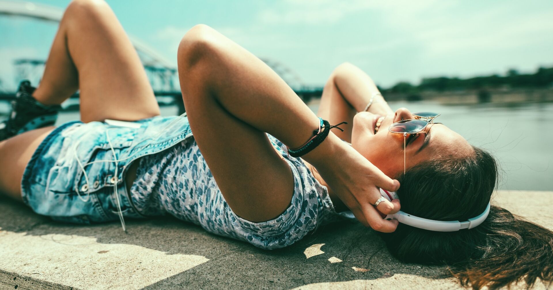 Ein Mädchen mit Kopfhörern an einem See.