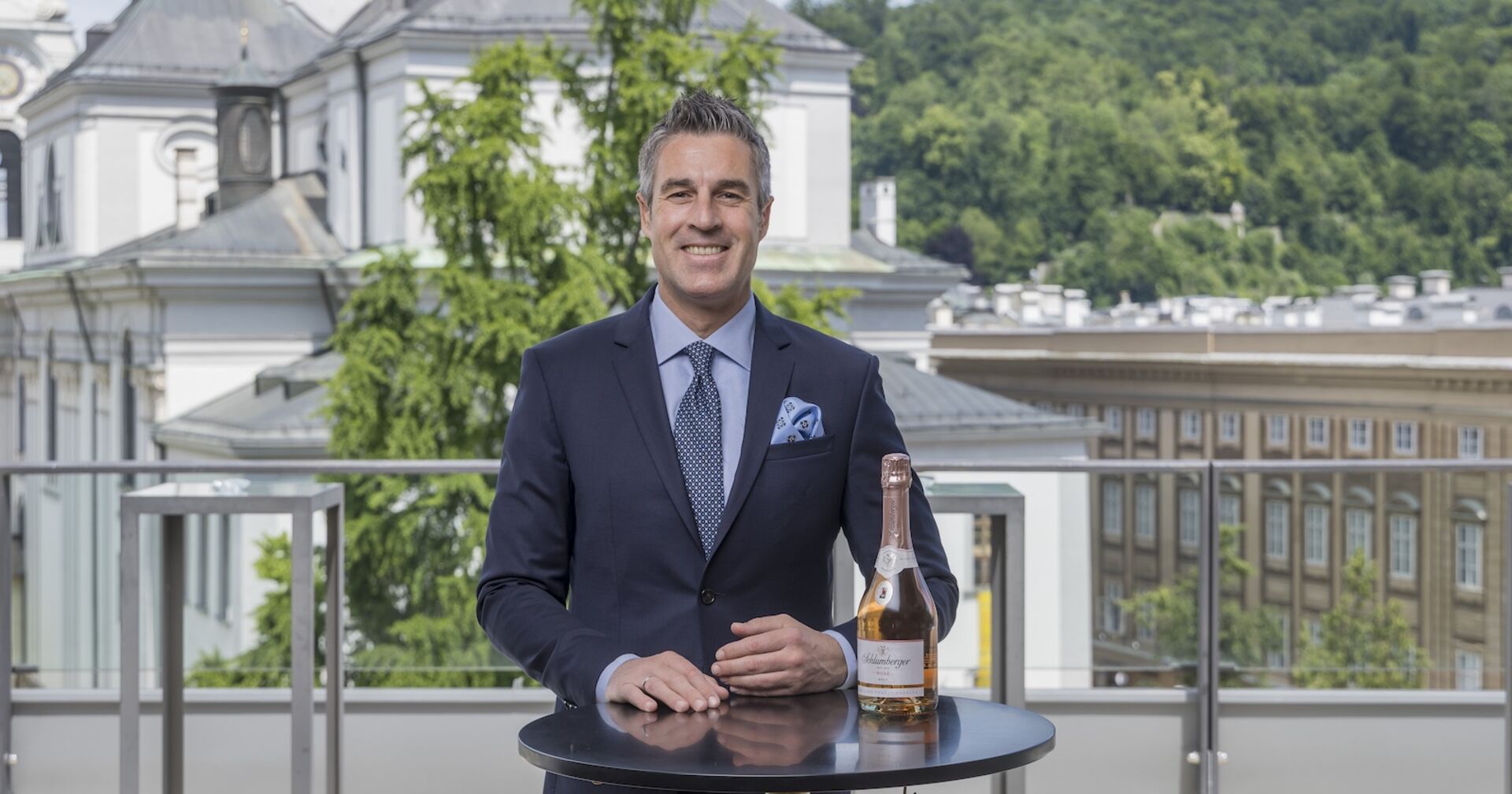 Porträt an Stehtisch mit Sektglas