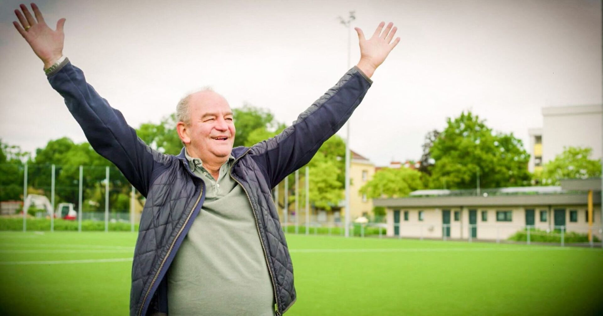 Herbert Prohaska streckt seine Arme auf einem Fußballplatz in die Höhe