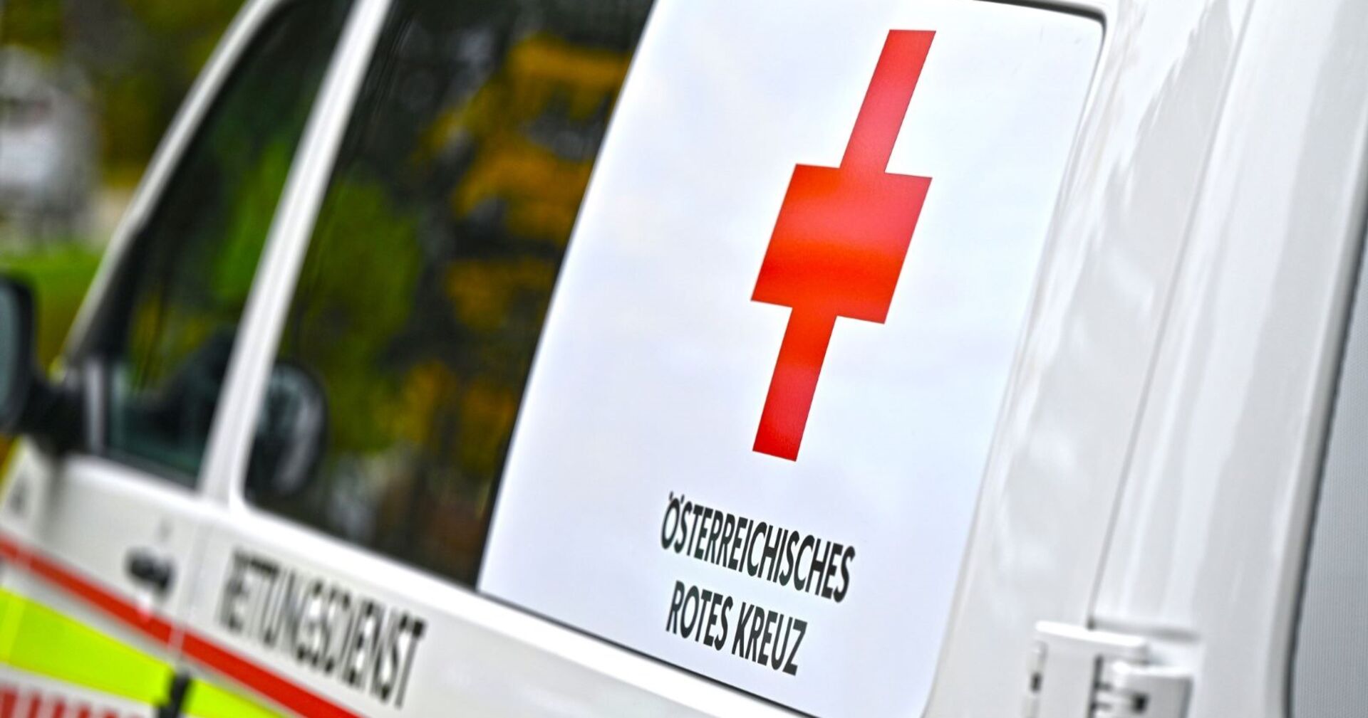 Seitliche Ansicht eines Rettungswagens des Österreichischen Roten Kreuzes mit rotem Kreuz auf weißem Hintergrund.