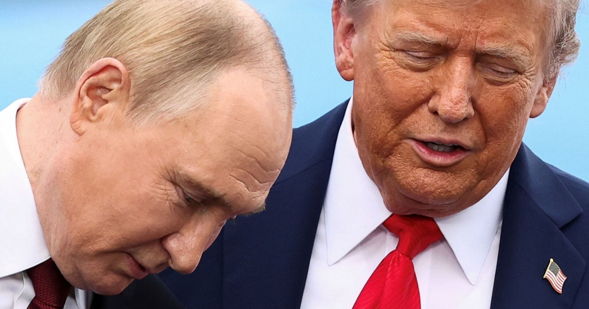 Wladimir Putin und Donald Trump stehen eng beieinander und wirken konzentriert im Gespräch. Putins Kopf ist leicht geneigt, Trump hat die Augen geschlossen und spricht.