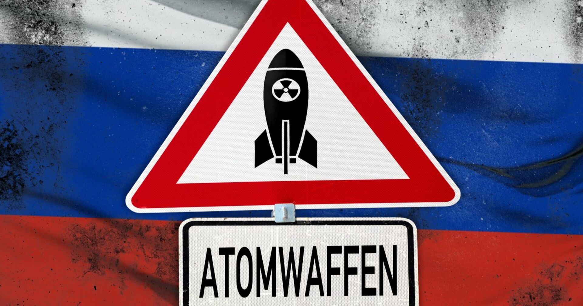 Atomwaffen, Schriftzug auf einem Warnschild mit Atombombe. Symbolbild globale Bedrohung: