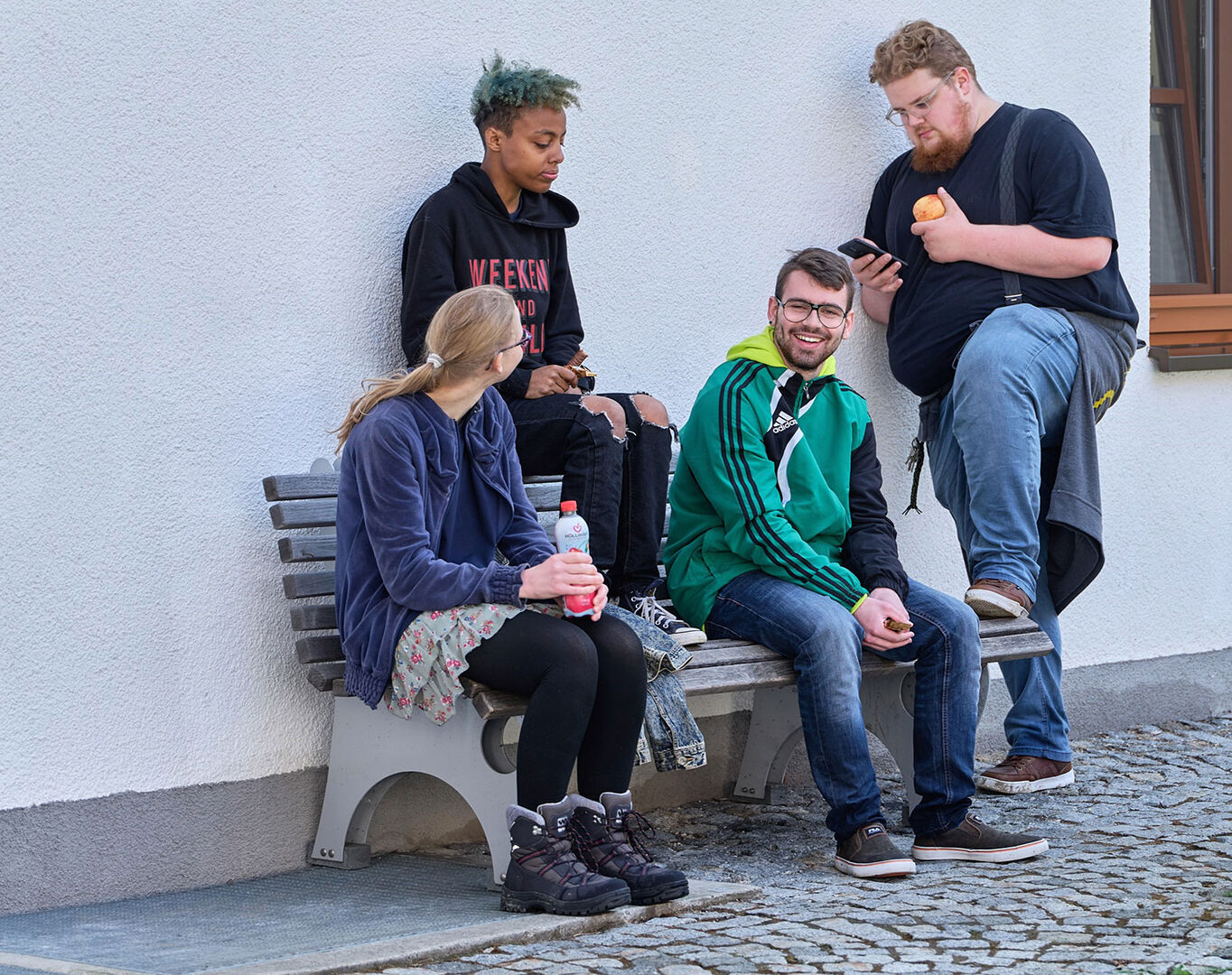 Gruppe Jugendlicher beim Zeitvertreib vor einem Haus | Credit: Fokus Mensch
