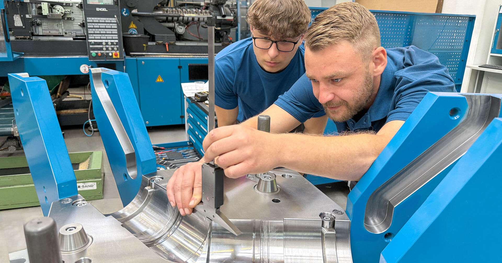 Ausbildner zeigt Lehrling Arbeitsschritte an der Werkbank | Credit: ifw mould tec