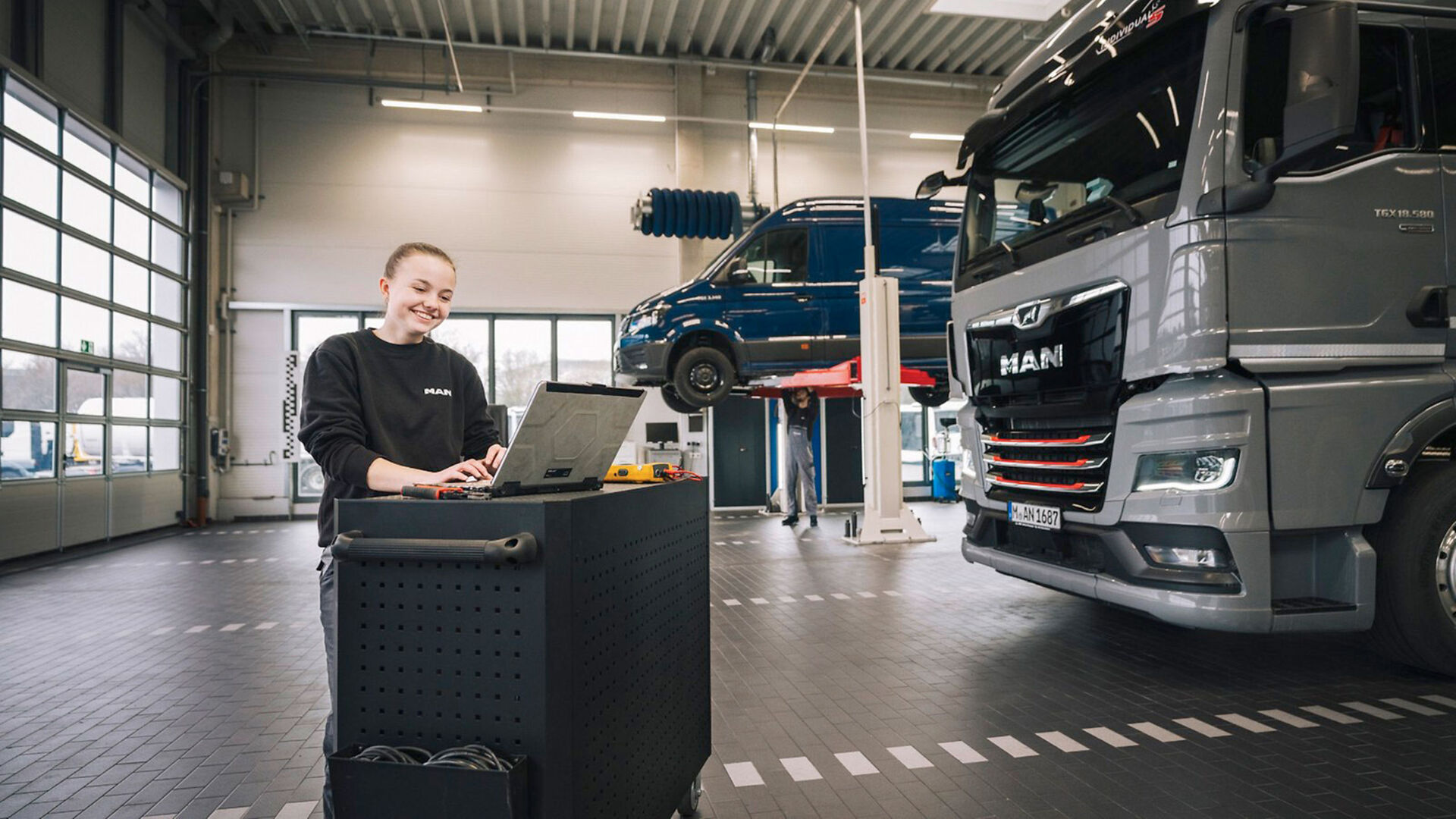 Junge Frau in einer Werkshalle hinter dem Notebook | Credit: MAN