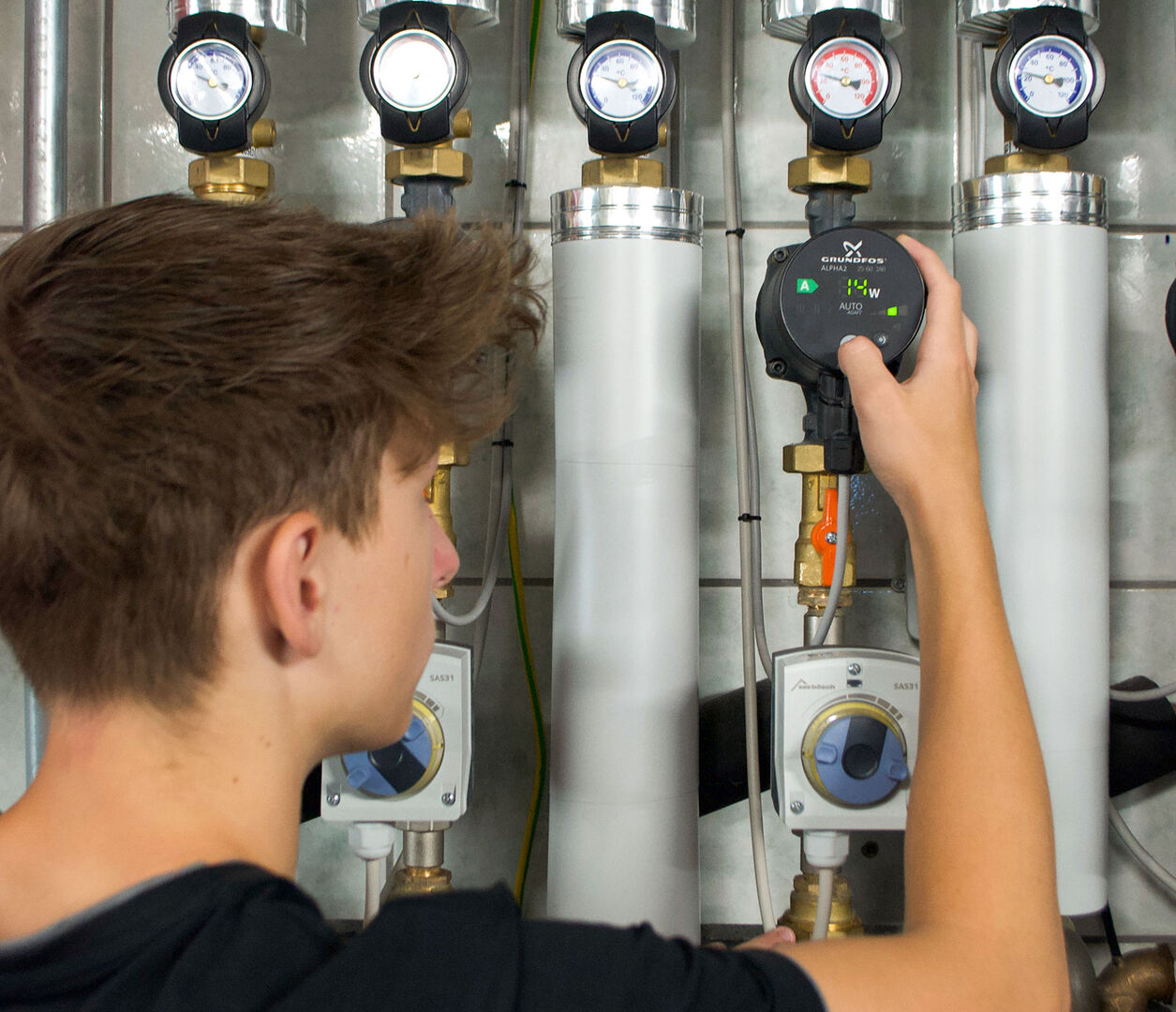 Junger Installateur überprüft den Druck | Credit: Schick Gebäudetechnik