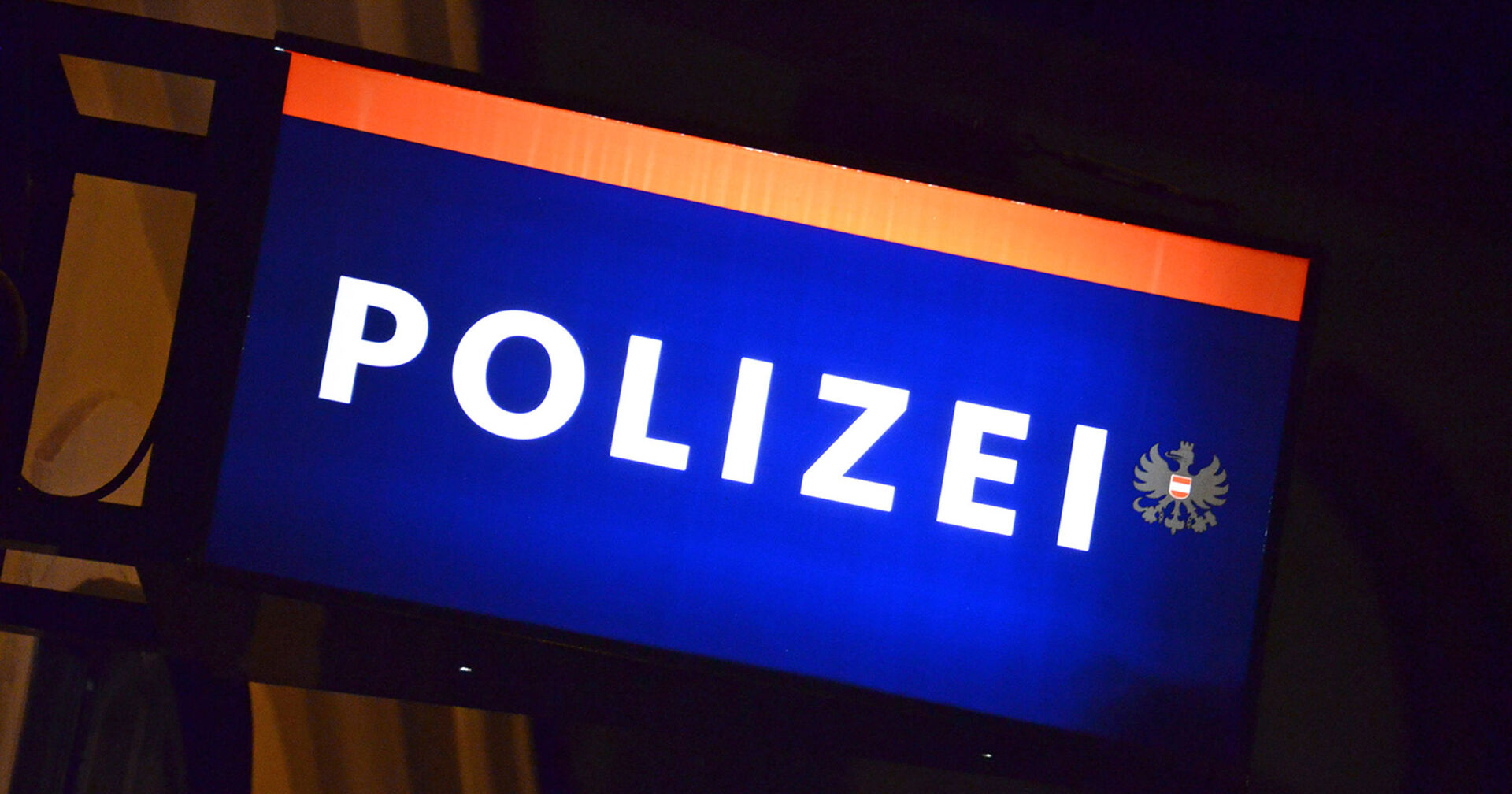 Symbolbild: Beleuchtetes Schild einer Polizeiinspektion