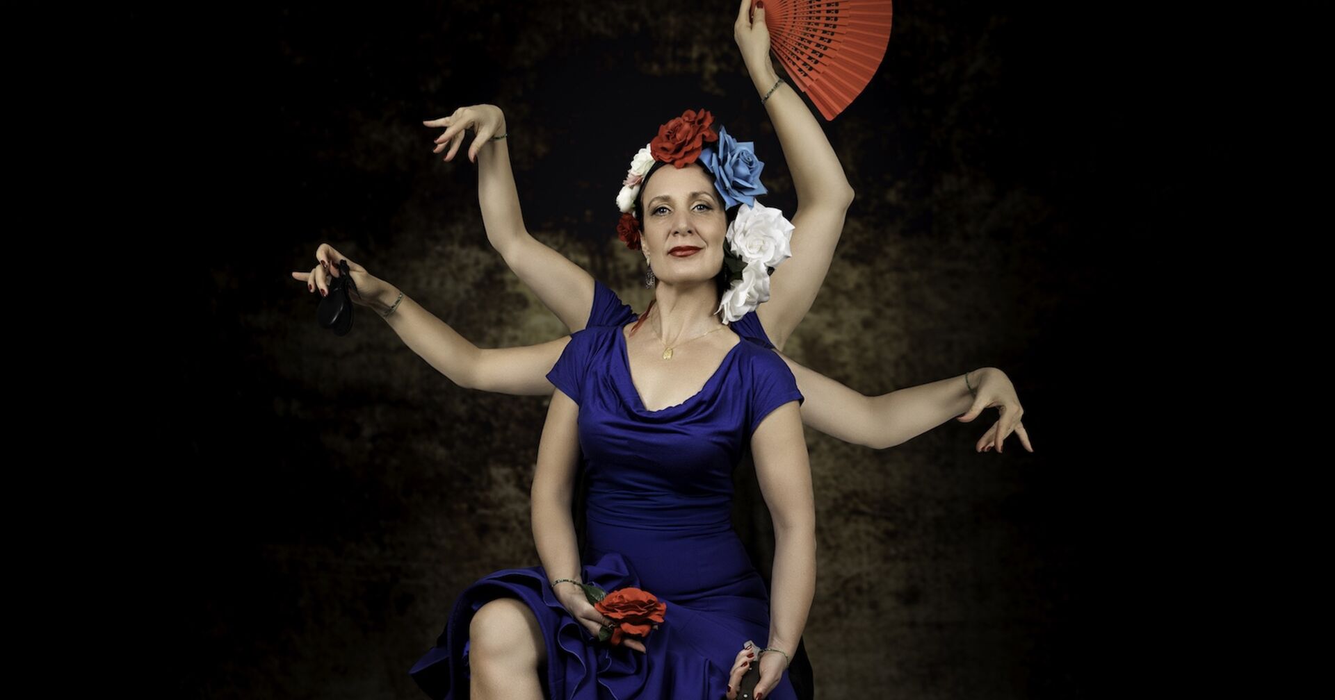 Frau in blauem Kleid mit scheinbar sechs tanzenden Armen