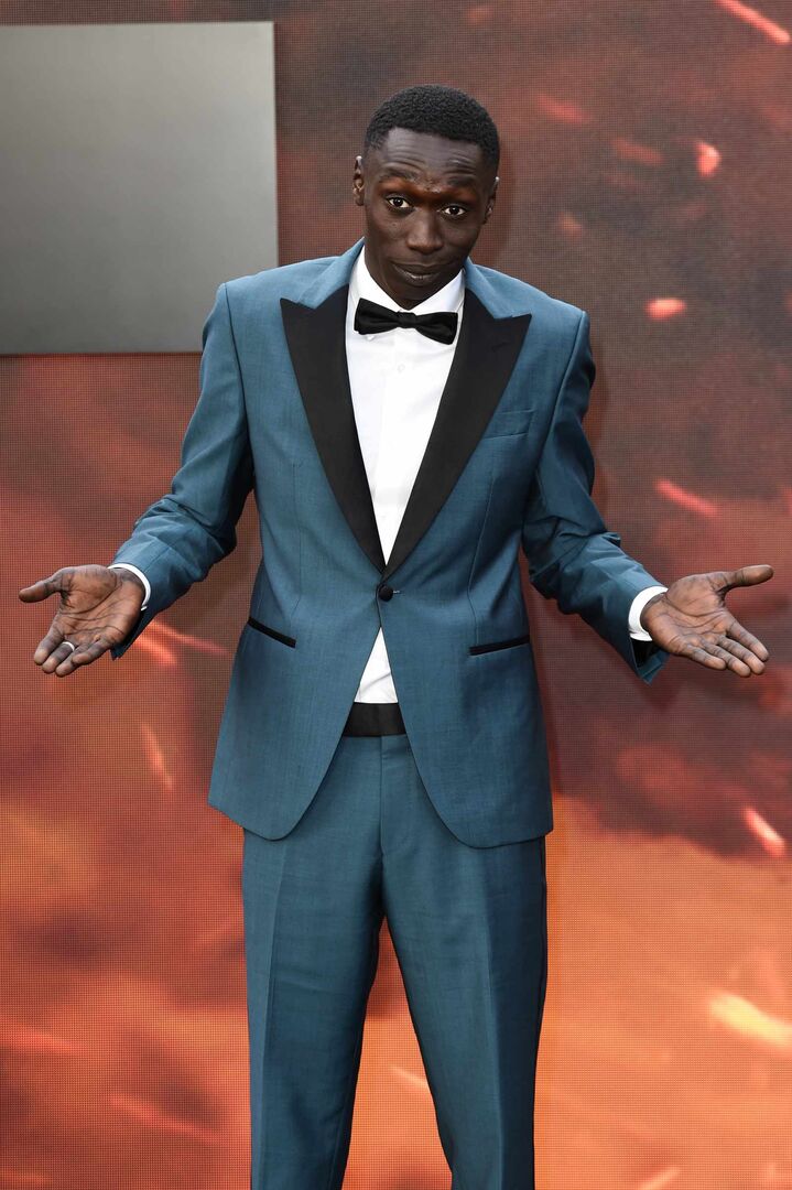 Khaby Lame im eleganten Anzug auf dem roten Teppich – vom arbeitslosen Fabrikarbeiter zum meistabonnierten TikTok-Star der Welt.