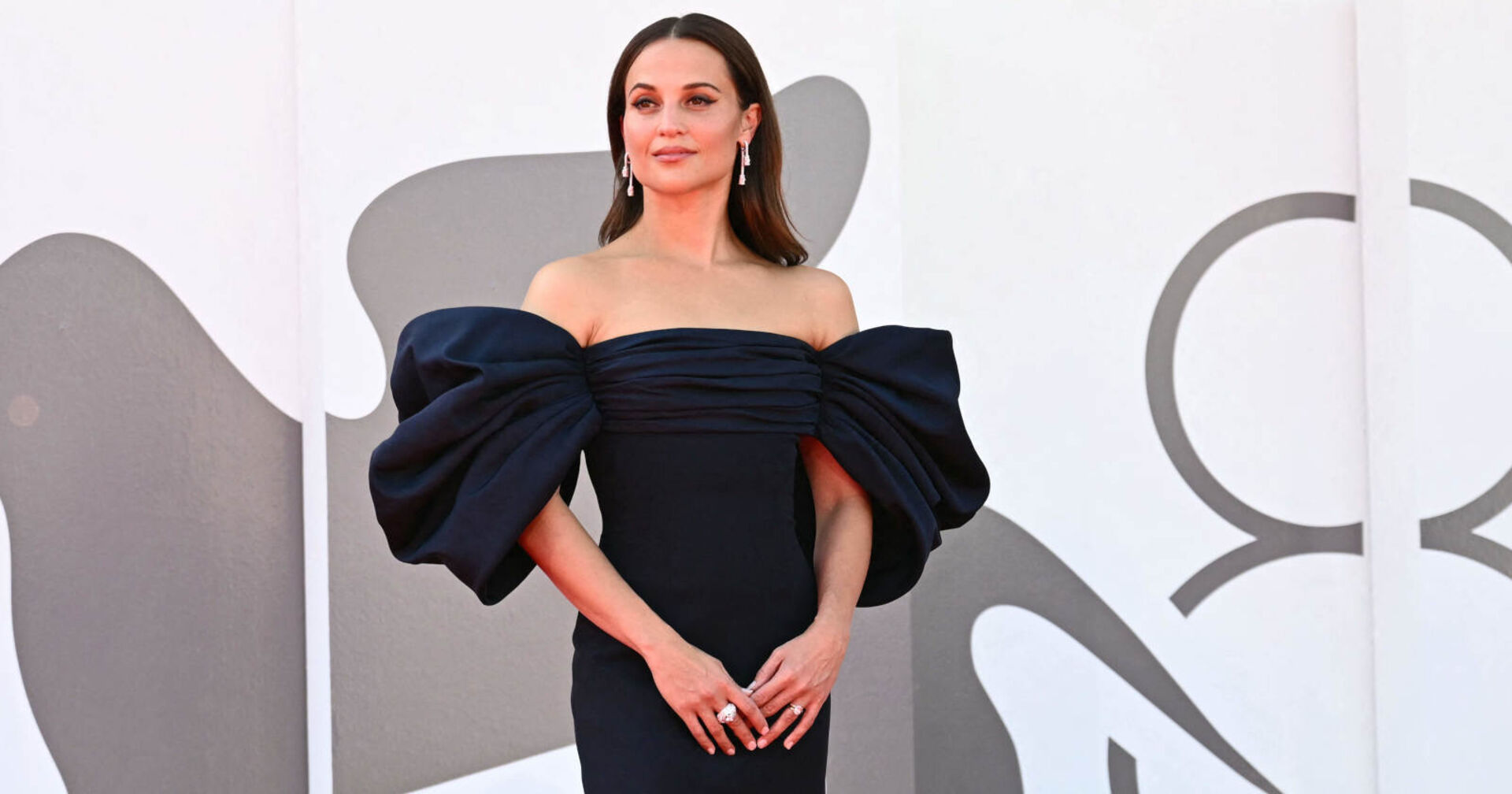 Eine Frau in einem dunkellauen Kleid steht am Roten Teppich