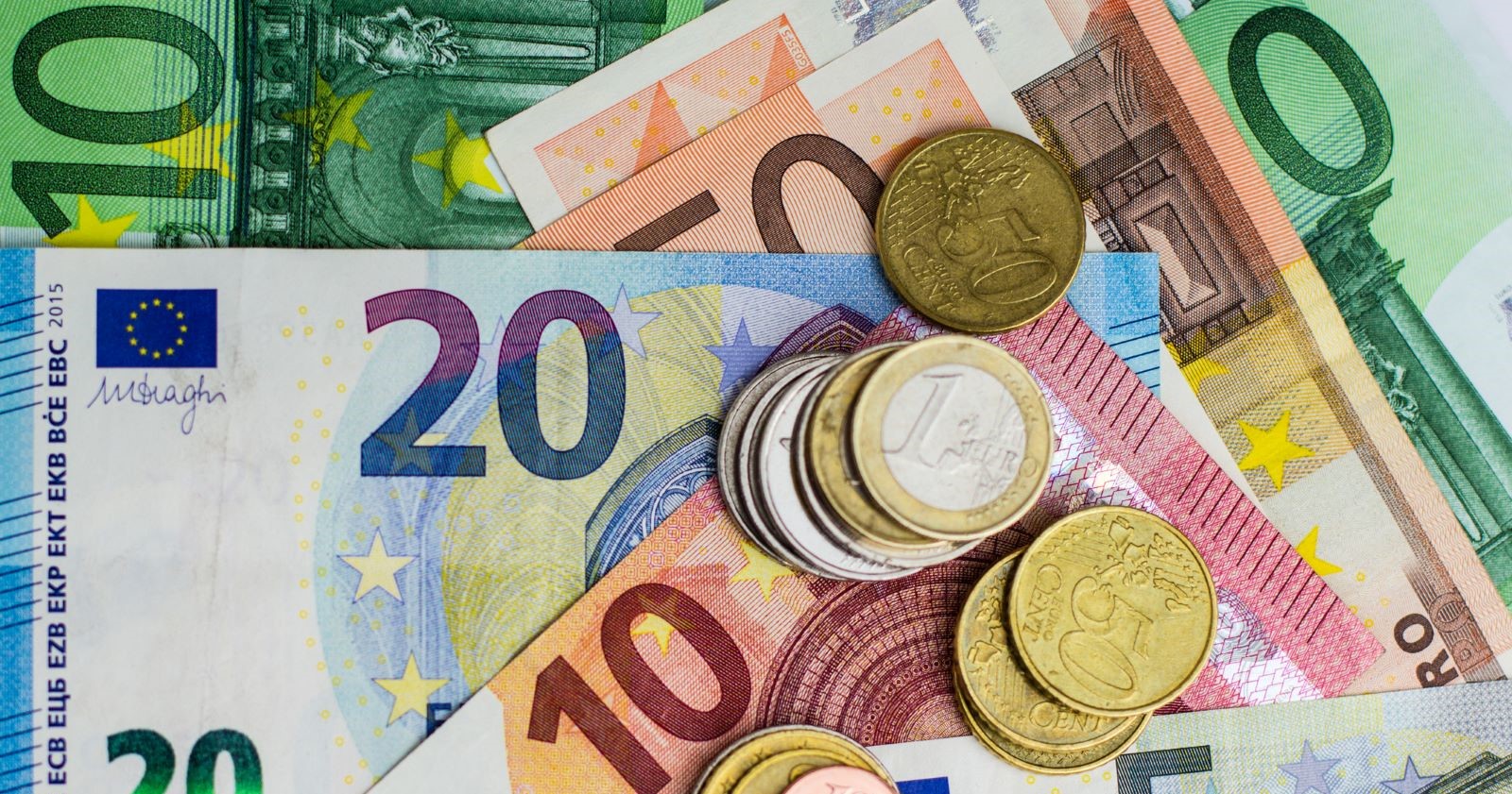 Verschiedenste Euro-Noten und Münzen auf einem Tisch liegend