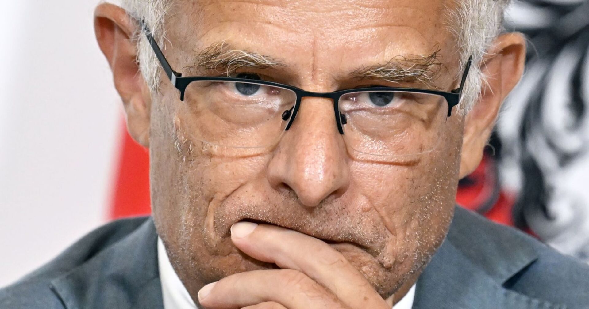 Nahaufnahme von Finanzminister Markus Marterbauer mit Brille und nachdenklichem Gesichtsausdruck, Hand an den Lippen.