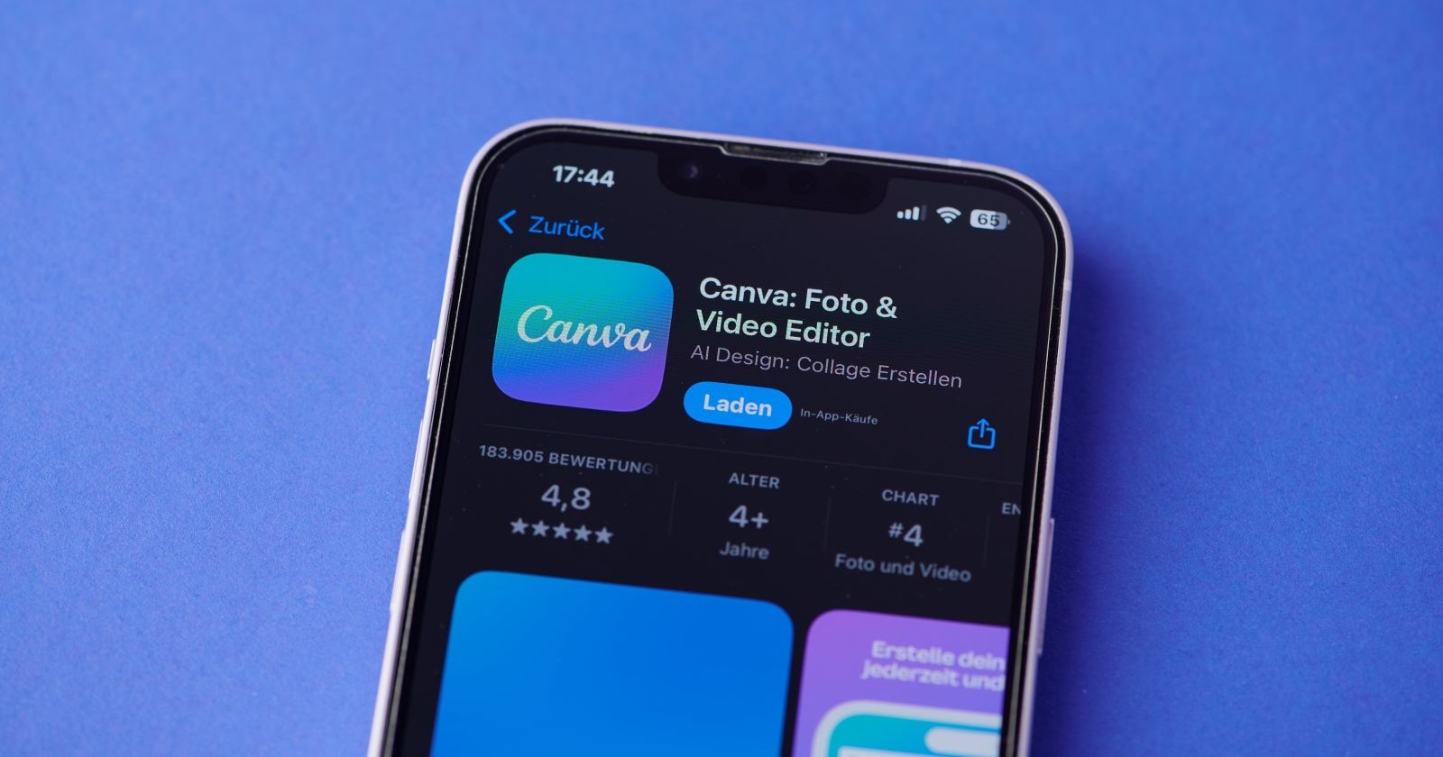 Ein Smartphone-Bildschirm zeigt das Canva-Logo auf einem iPhone im Apple-App-Store vor blauem Hintergrund