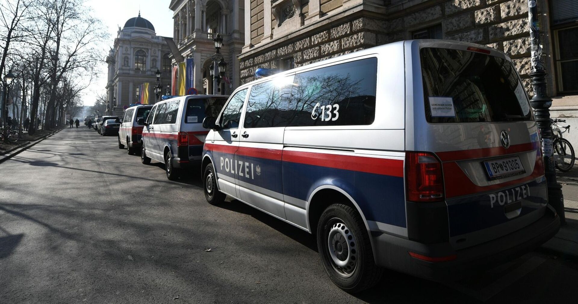 Polizeifahrzeuge stehen vor der Universität Wien, während Beamte bei einer Gaza-Demonstration im Großeinsatz sind.