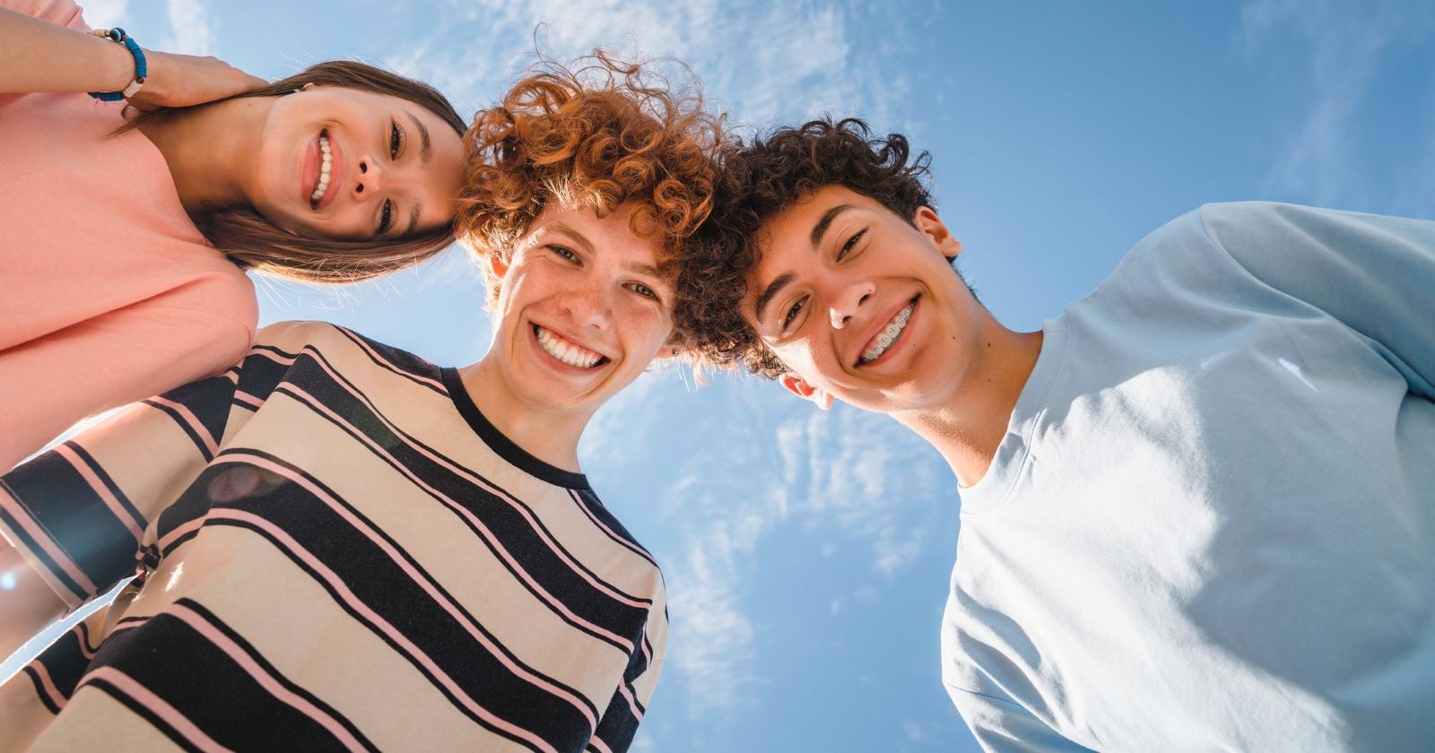 Nahaufnahme von lustig lächelnden Teenagern, die stehen und in die Kamera schauen