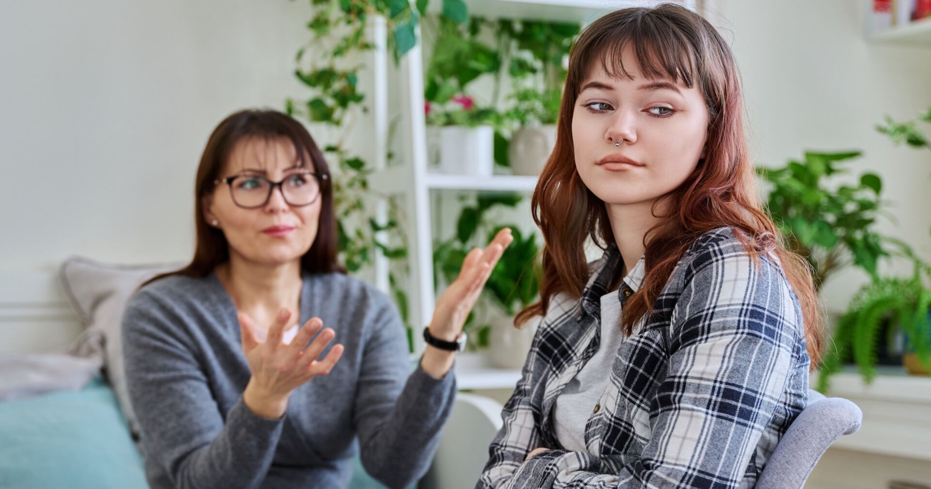 Mutter diskutiert heftig mit Tochter im Wohnzimmer