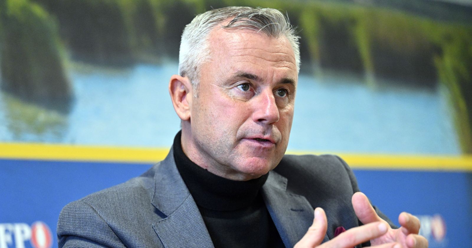 Norbert Hofer in schwarzem Rollenkragenpullover erklärt leicht gestikulierend im Halbportrait