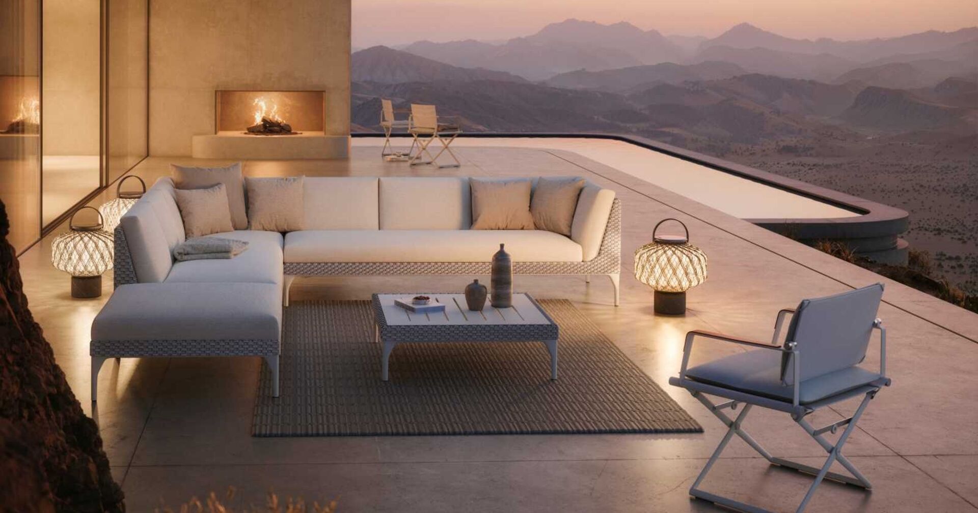 Stilvolle Terrasse mit moderner Lounge-Garnitur, Laternenbeleuchtung und Bergpanorama bei Sonnenuntergang; gemütliche Outdoor-Atmosphäre mit Kamin und Pool.