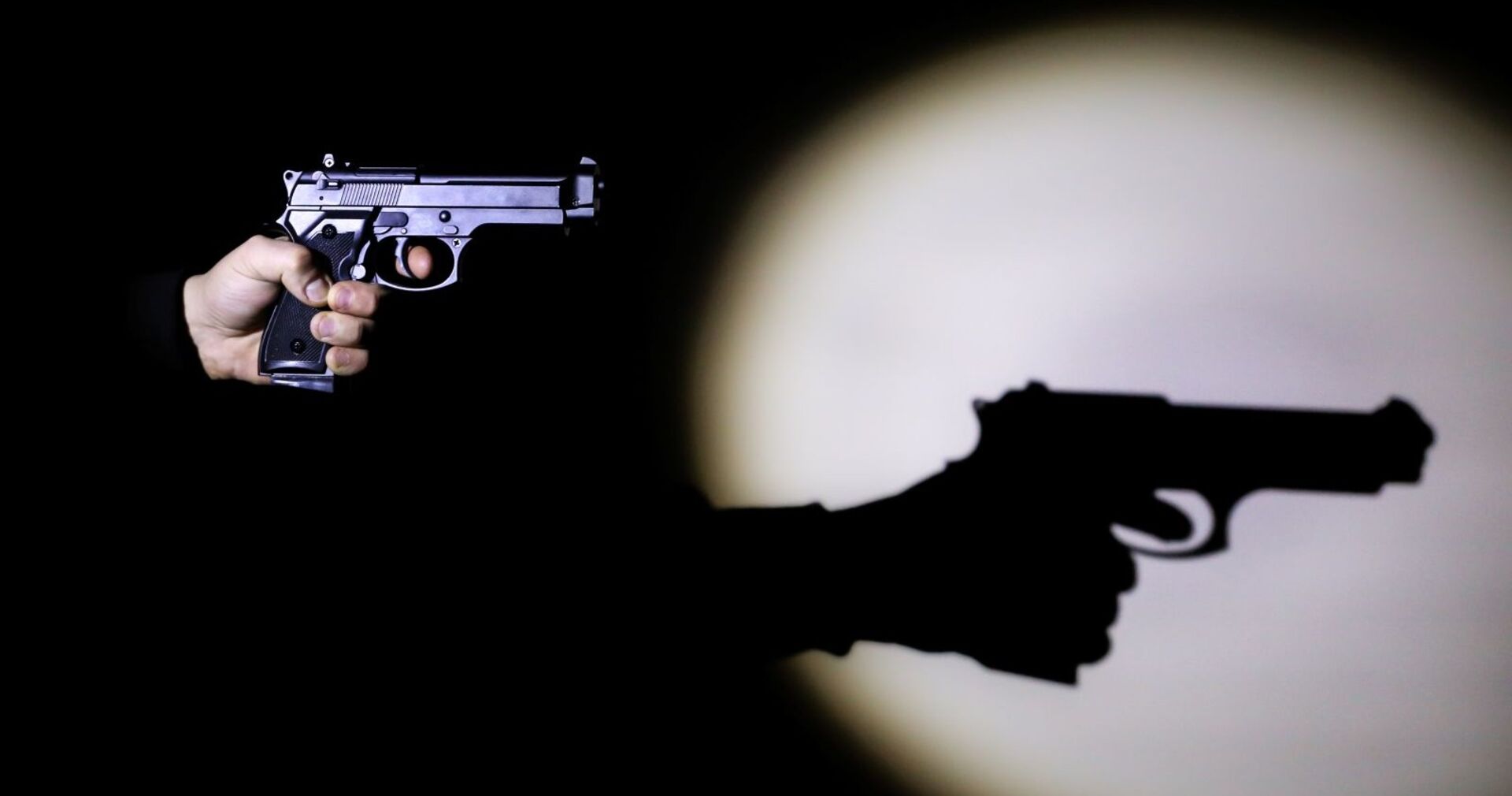 Ein Mann mit einer Schusswaffe im Dunklen.