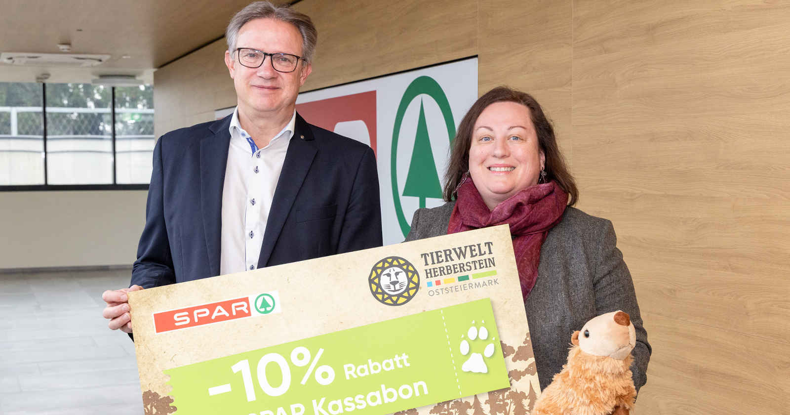 Mann und Frau halten ein großes Plakat hoch