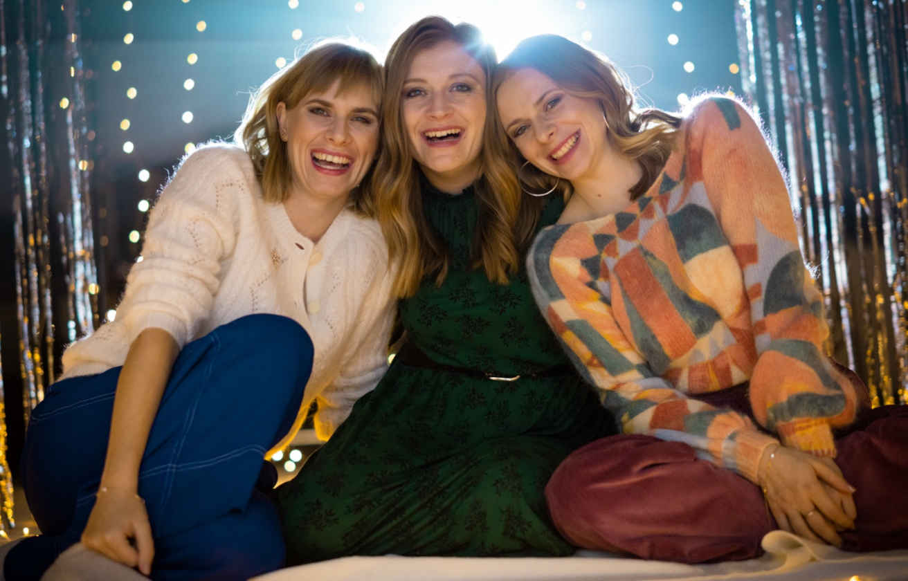 Drei Frauen lächeln und umarmen sich