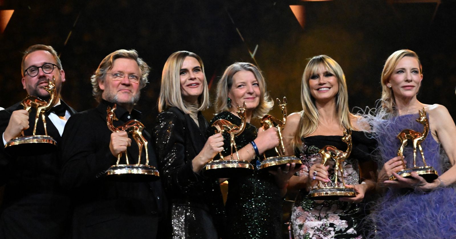 Gruppenfoto auf der Bühne: Mehrere Ausgezeichnete halten goldene Bambi-Trophäen bei der Bambi-Verleihung 2025 in München.