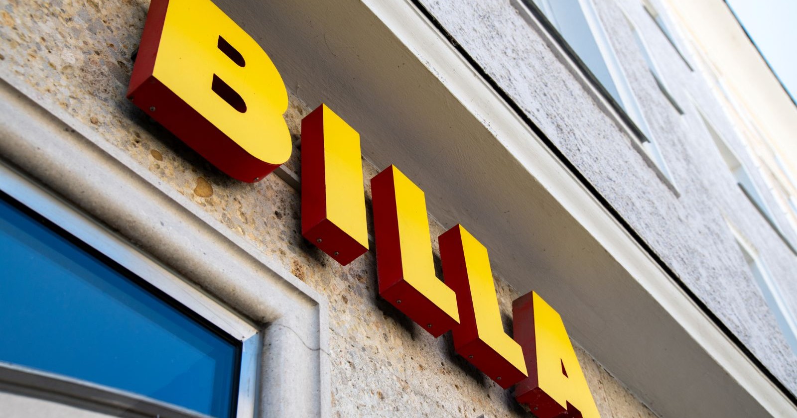 Fassade eines BILLA-Geschäfts mit gelb-rotem Logo, Symbol für die REWE-Gruppe, die den Rückruf der Clever-Punschkrapfen bekanntgegeben hat.